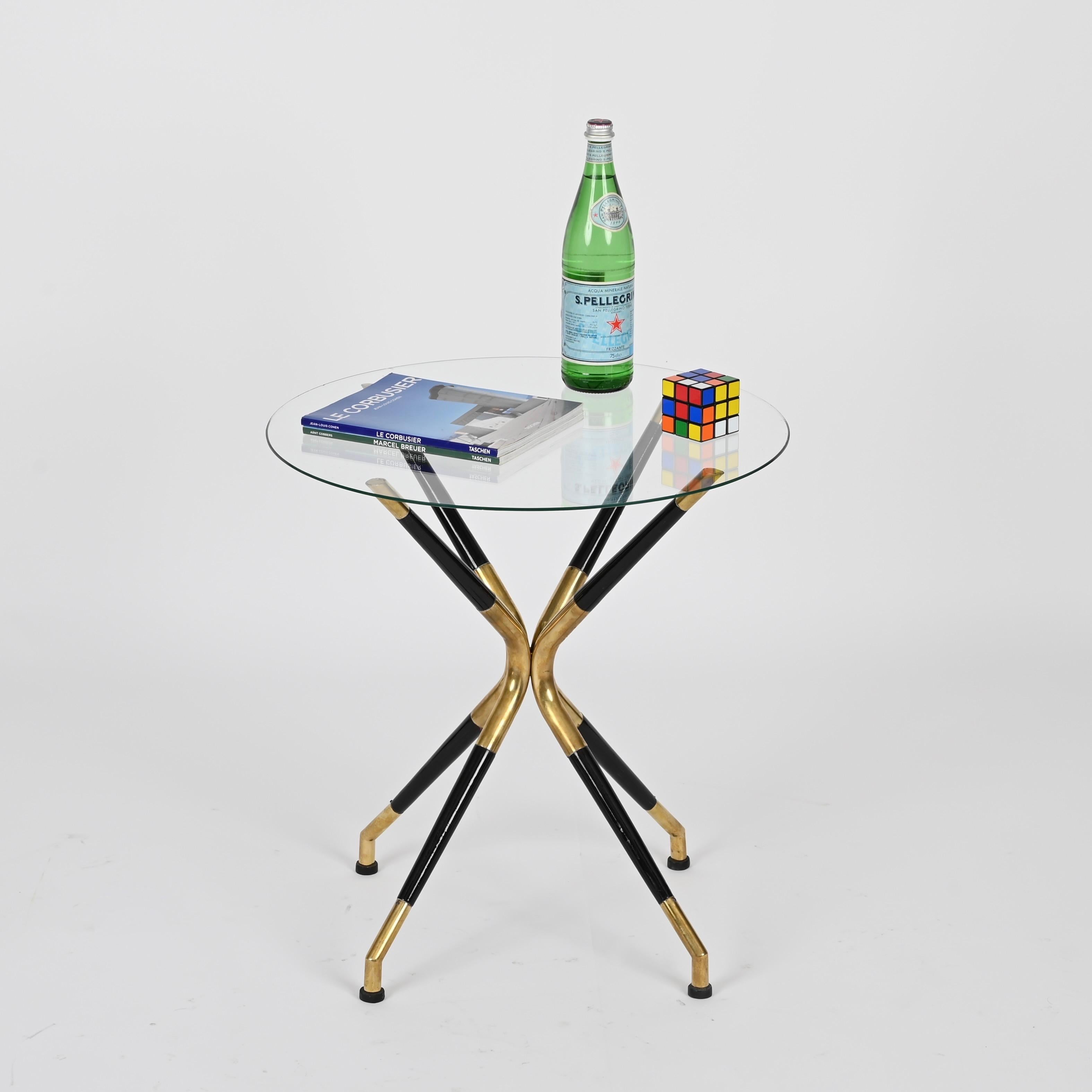 Marvelous and unique mid-century side table in black lacquered wood and brass completed by a round crystal glass. This incredibly elegant piece wasdesigned by Cesare Lacca and produced in Italy during the 1950s. 

Fully original and in fabulous