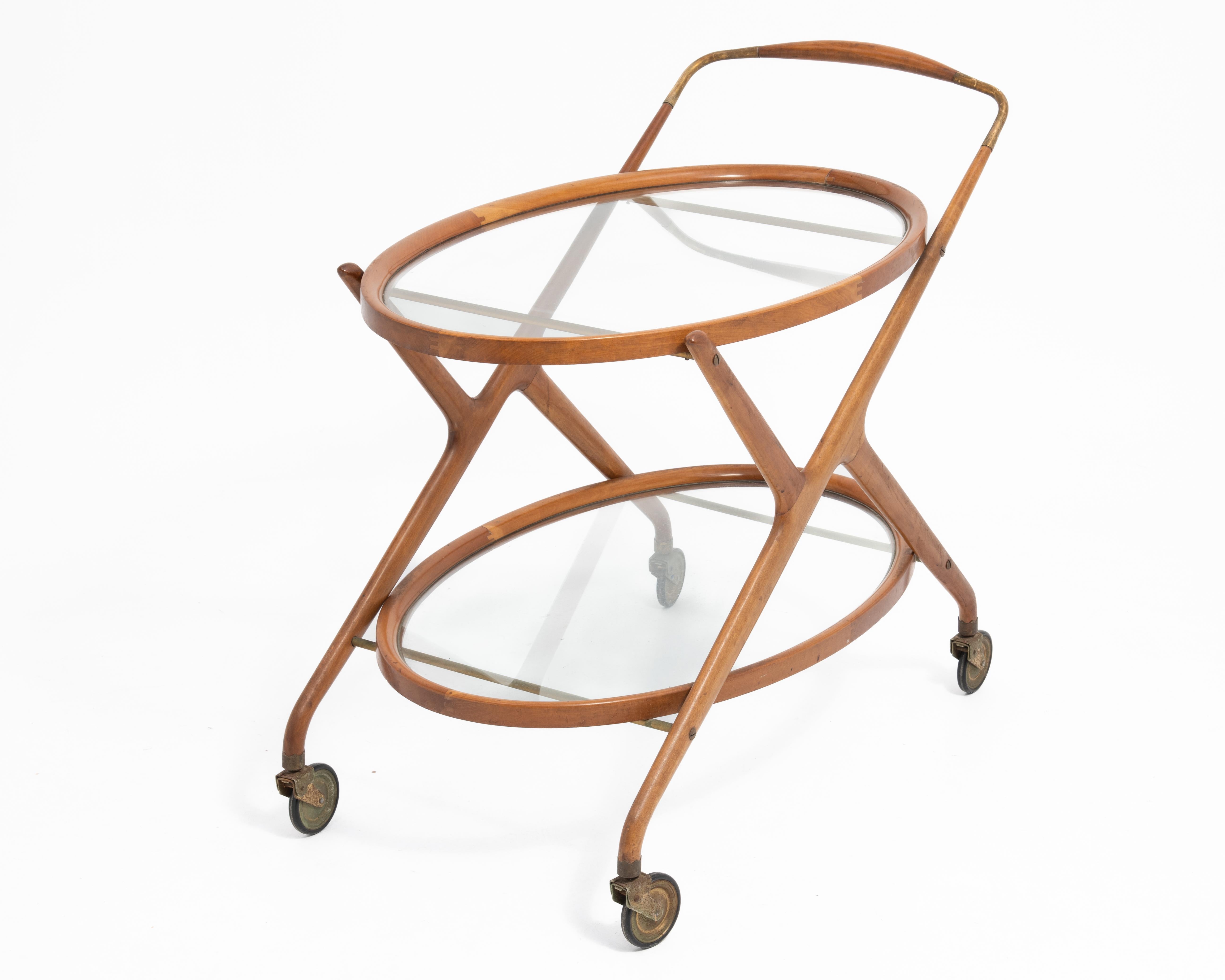 Cesare Lacca Italian Mid-Century oval bar cart, serving trolley or tea cart. Teak and brass with two glass shelves, and casters. Lightly cleaned with original patina. This cart was featured in the Great Room of the 2025 Bucks County Designer House.