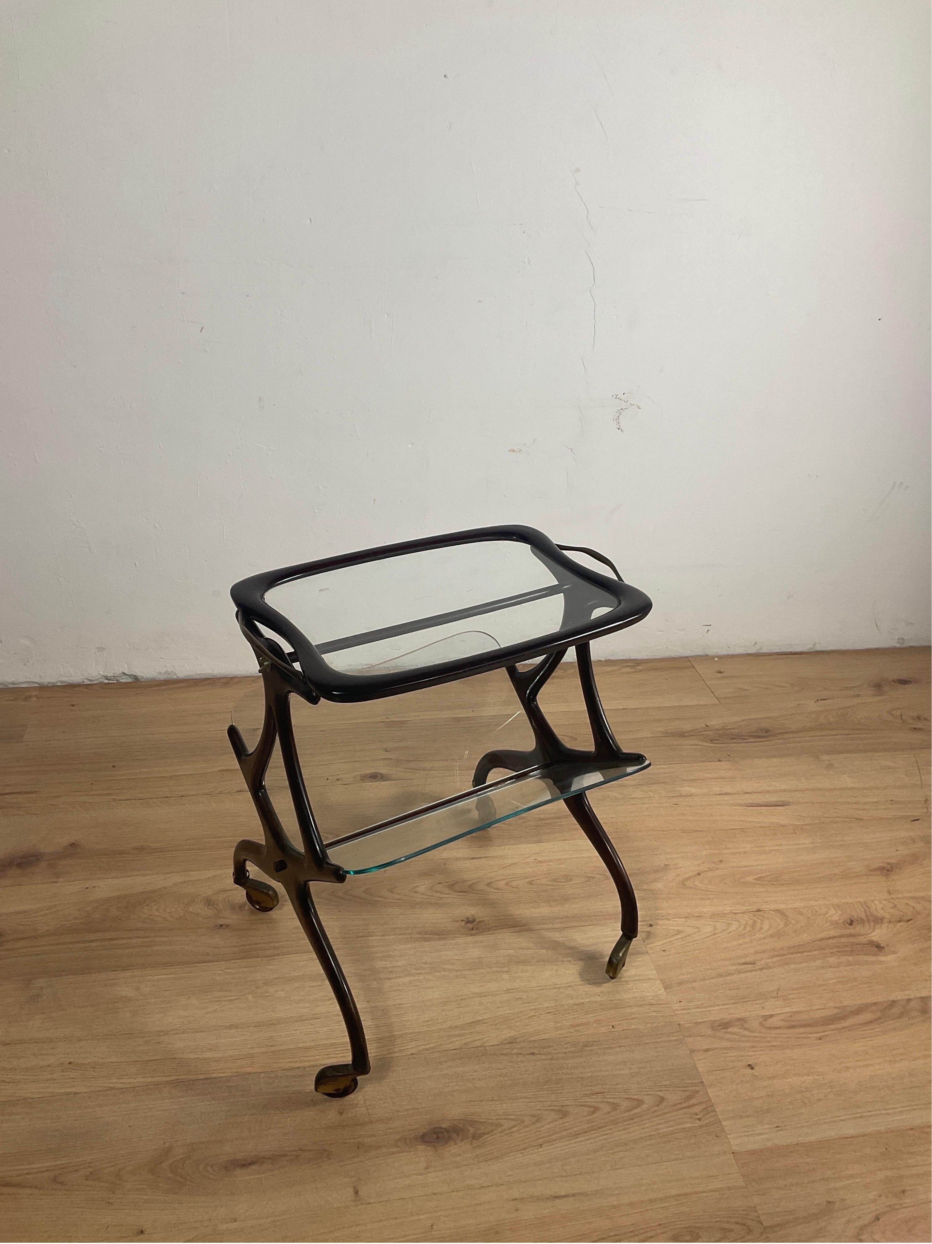Magazine trolly Cesare Lacquer from the 50s in wood with three glass surfaces and very nice golden metal wheels to store magazines efficiently and also easily transportable.