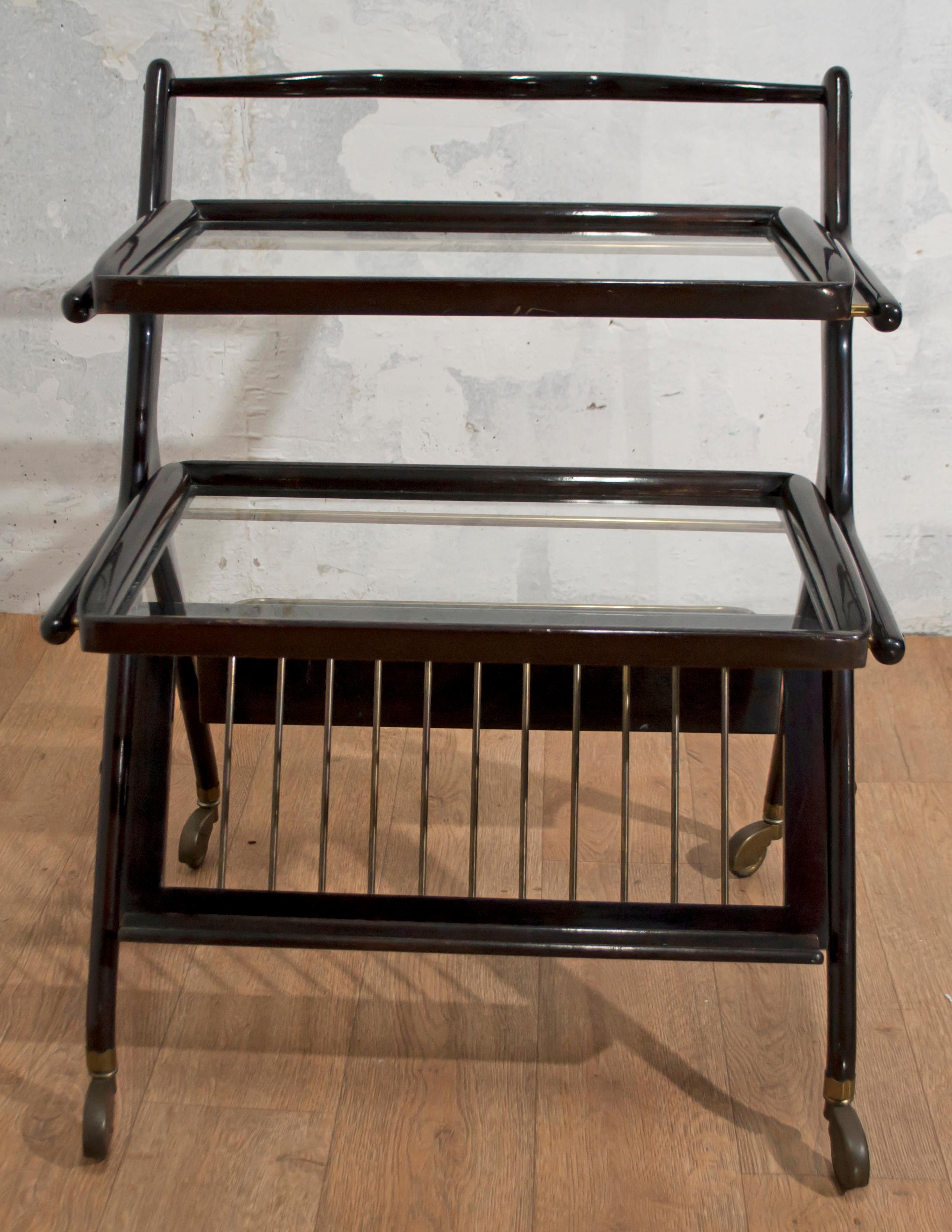 This bar trolley in mahogany and brass was designed by Cesare Lacca, has both removable trays, and a lower front level for magazines, rear for bottles.

