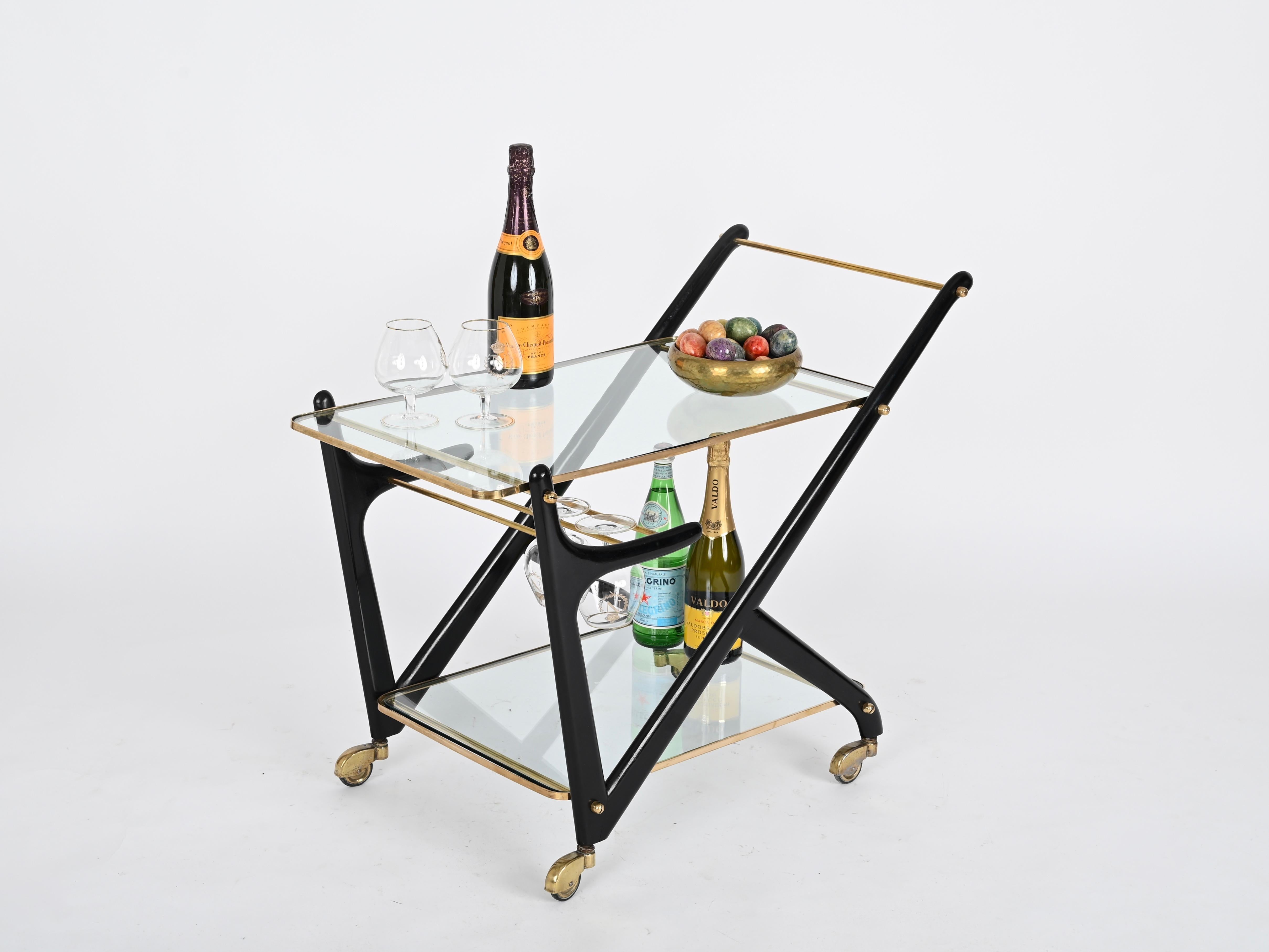 Stunning mid-century bar cart in ebonized wood and brass. This incredibly elegant piece was designed by Cesare Lacca and produced in Italy during the 1950s.

In fabulous condition. This serving bar cart is extremely elegant thanks to the sinuous