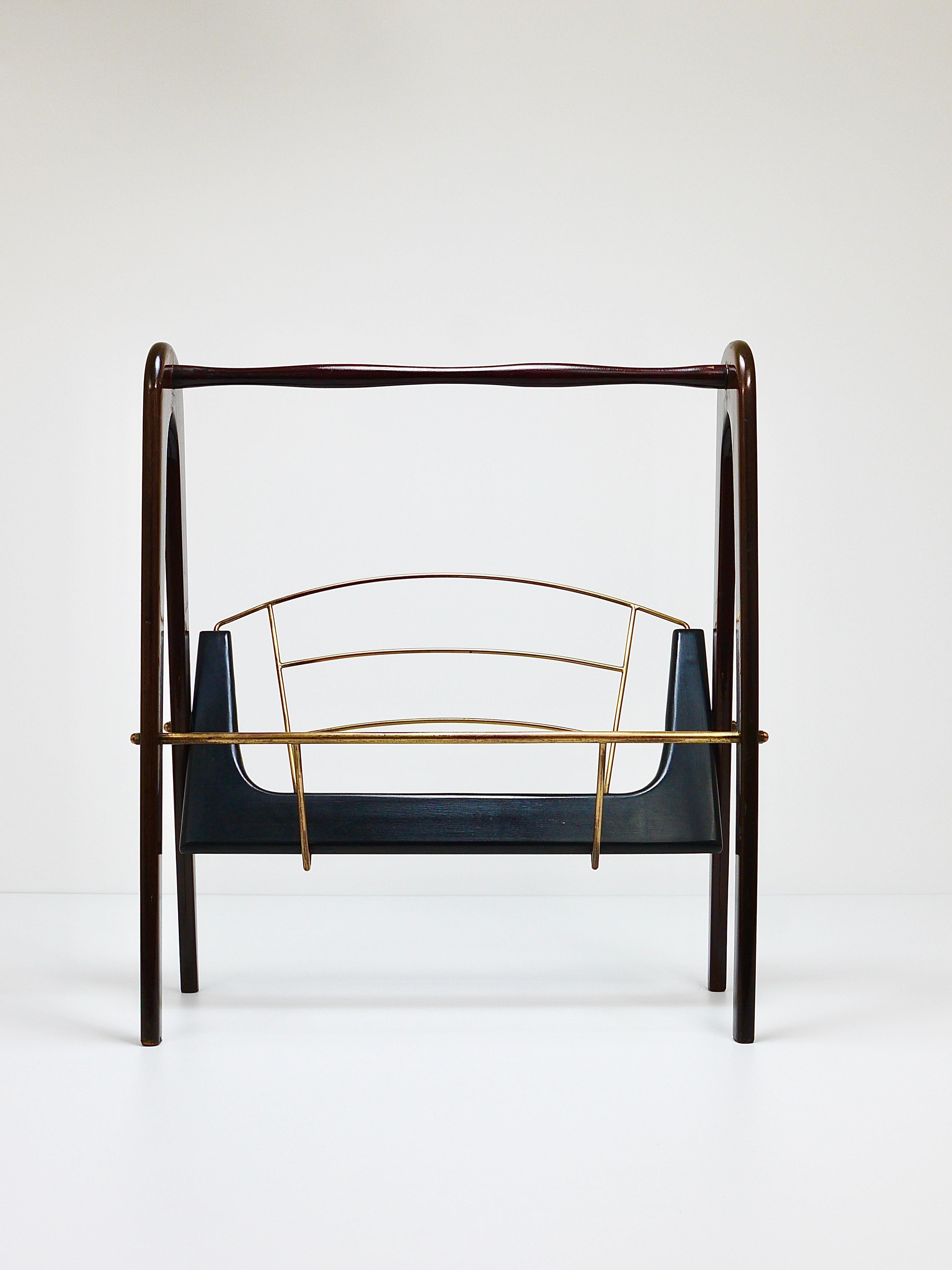 A beautiful and lovely shaped Italian midcentury newspaper stand / magazine rack from the 1950s by Cesare Lacca. Made of mahogany and black wood with nice brass details. In good condition with charming age-related patina. In the style of Ico Parisi.