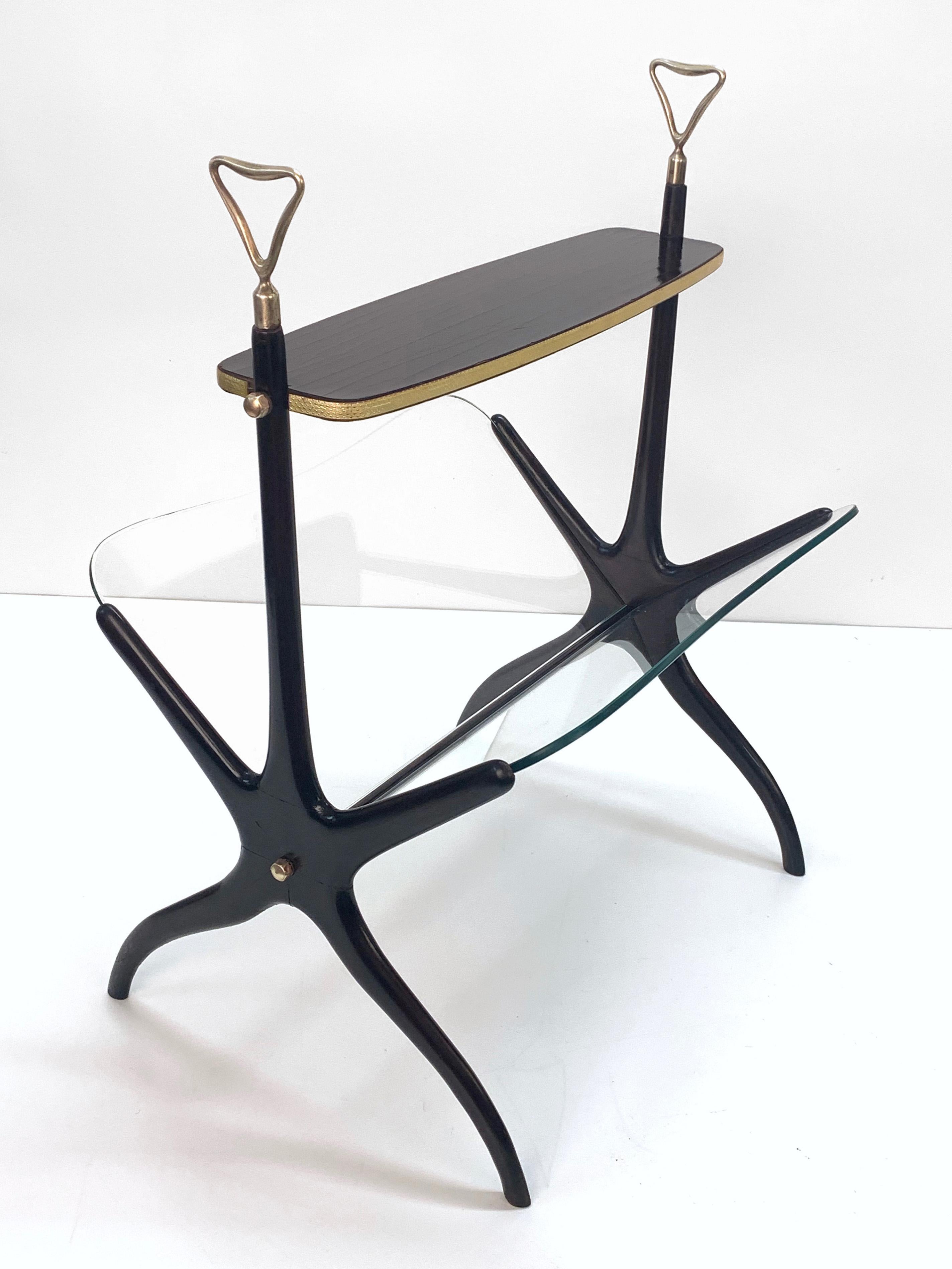 Wonderful midcentury black lacquered mahogany magazine rack. This great item was designed in Italy during the 1950s by Cesare Lacca.

It has a top mahogany base and a bottom double glass trays.

This fantastic piece is in wonderful vintage