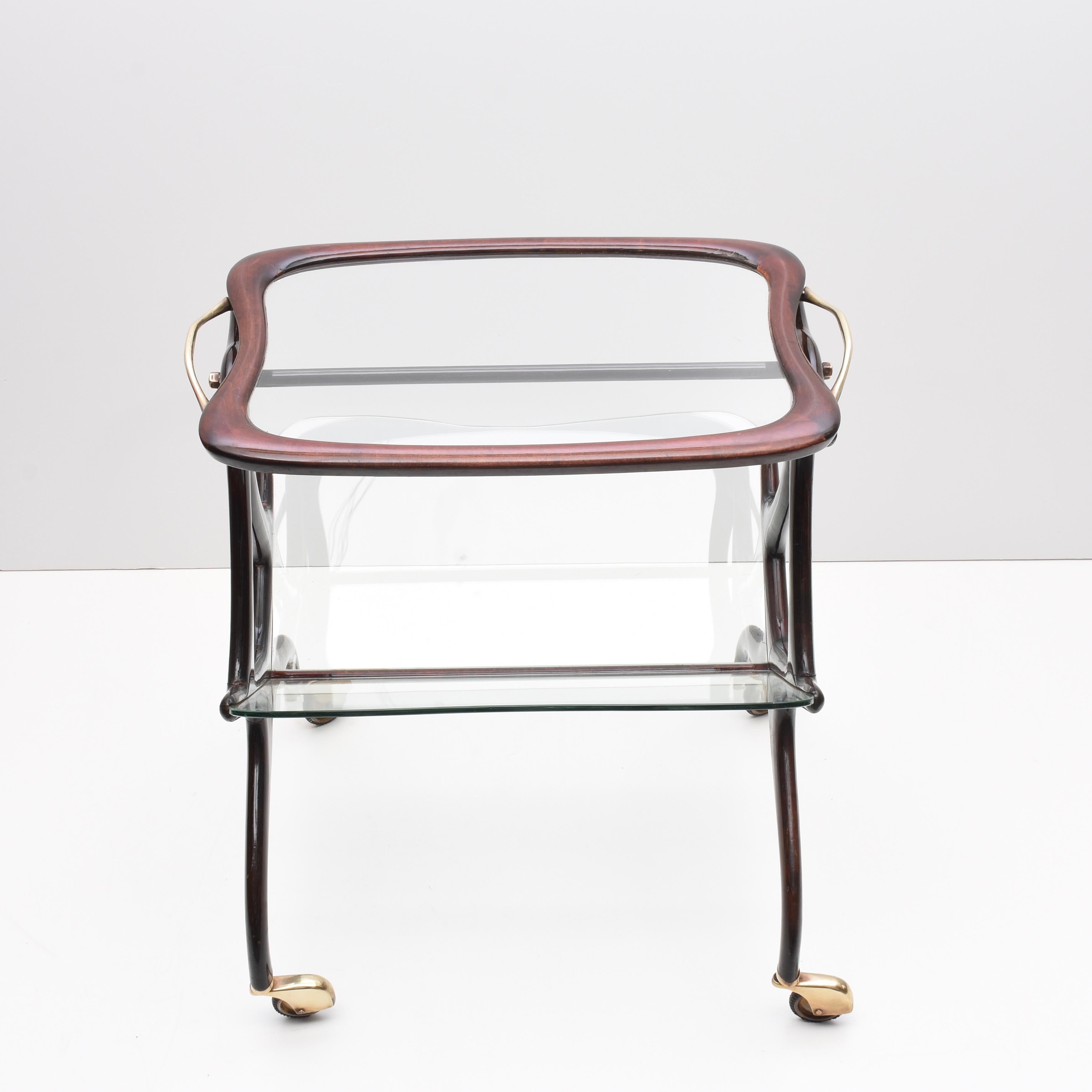 Amazing Mid-Century Modern wood magazine rack and bar cart. This wonderful piece was designed in Italy during 1950s by Cesare Lacca.

This item is in a magnificent vintage condition, it is made of glass tray and wood designed in sinuous and elegant