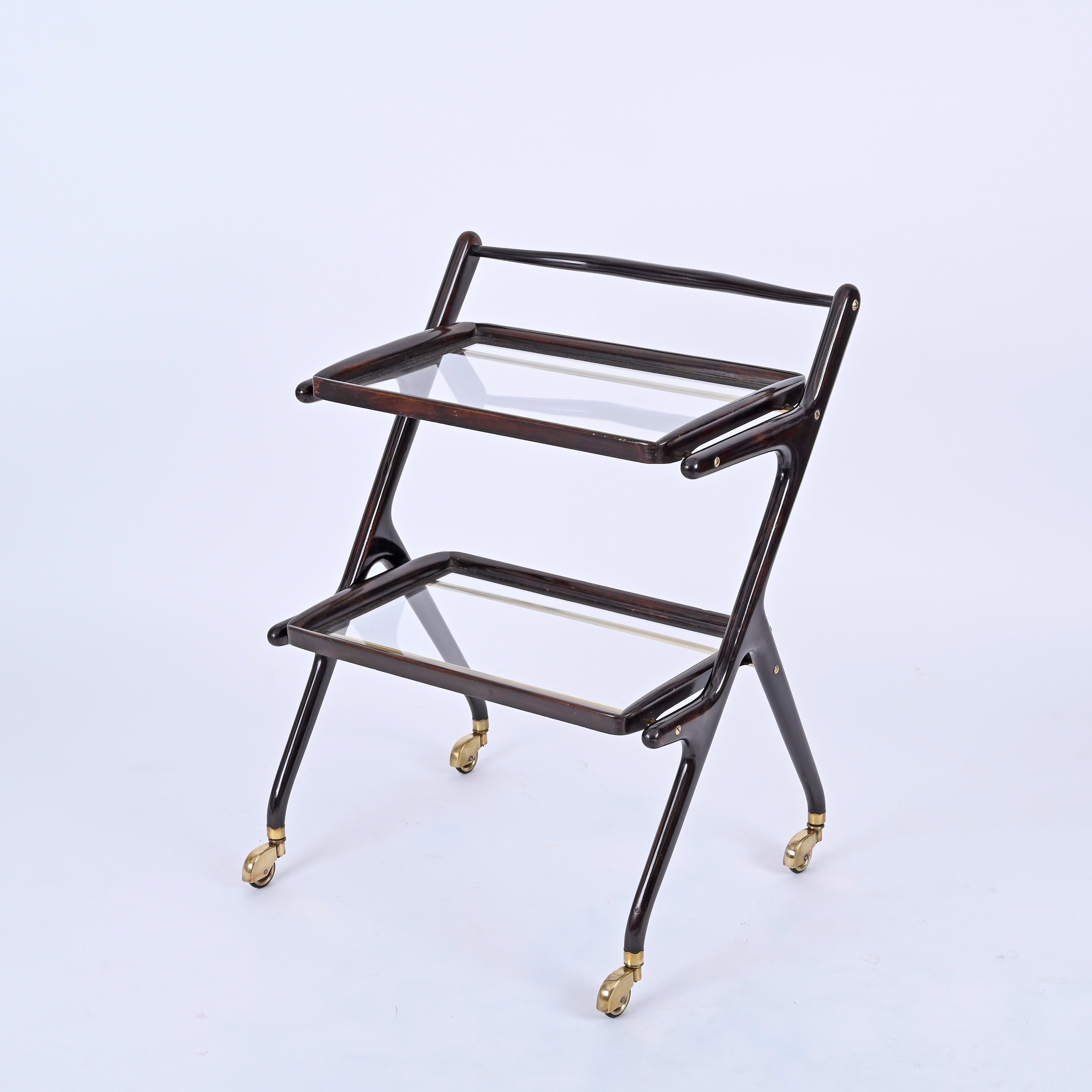 Gorgeous midcentury bar cart in wood and brass with two removable crystal glass trays.  This wonderful object designed by Cesare Lacca in Italy during 1950s.

This structure of this serving table is fully made in a wonderful stained walnut with