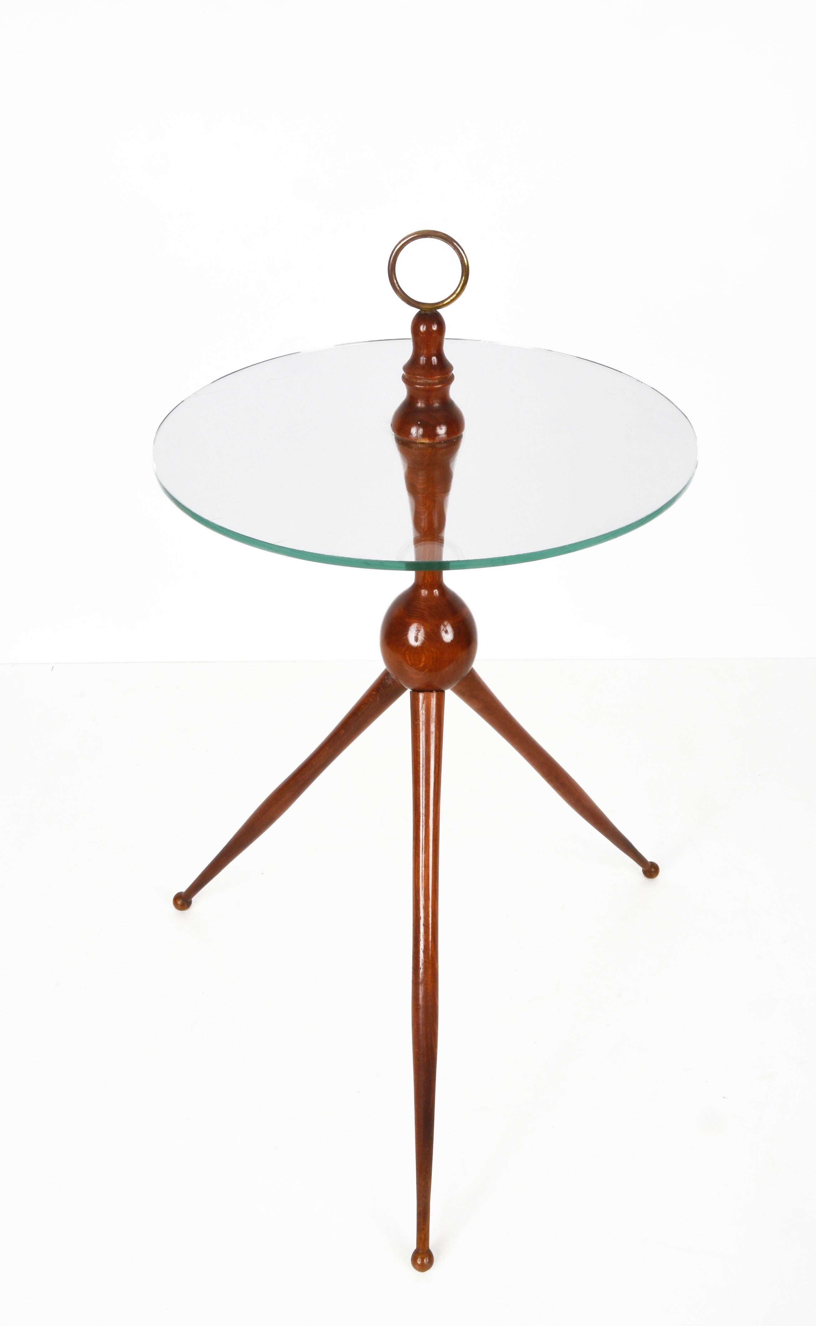 Amazing midcentury wood and glass tripod coffee table with brass finishes. This outstanding piece was designed in Italy during the 1950s by Cesare Lacca.

This elegant midcentury coffee table is a symbol of excellent workmanship by iconic designer