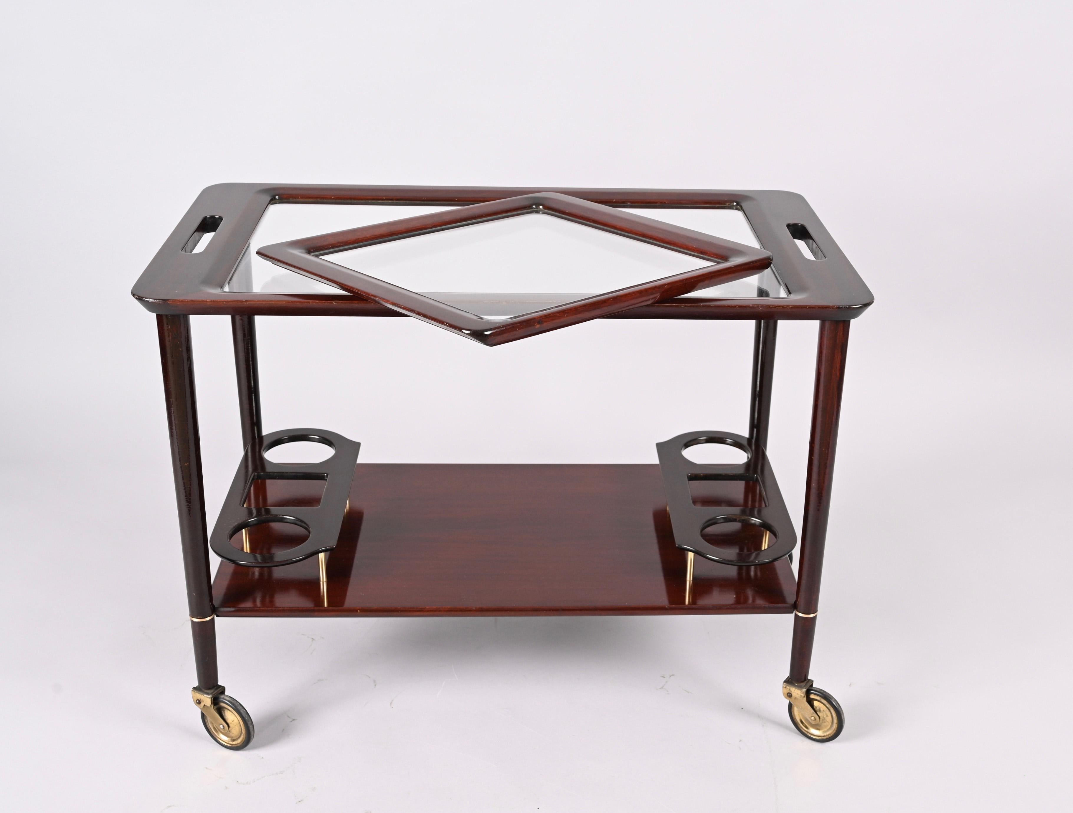 Fantastic midcentury wood bar cart with glass serving trays. Cesare Lacca probably designed this amazing piece in Italy during the 1950s.

This wonderful serving piece comes with a removable glass tray and has an ergonomic wooden bottle holder,