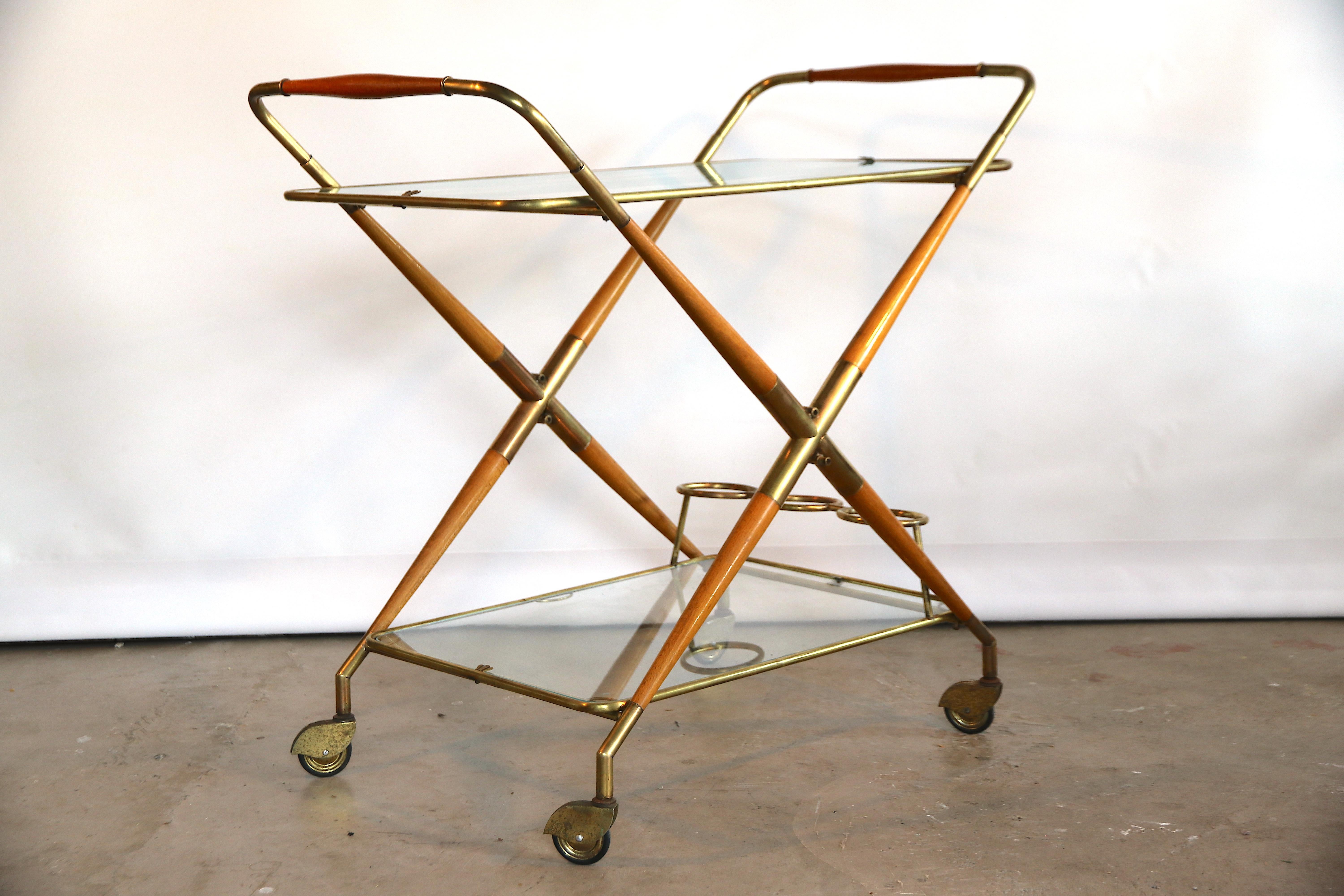 Wonderful bar cart or serving trolley designed by Cesare Lacca with 2 removable serving trays, of which the lower has 3 full brass bottle holders. The trays are fitted with little legs and can be used apart from the trolley base, while the base can