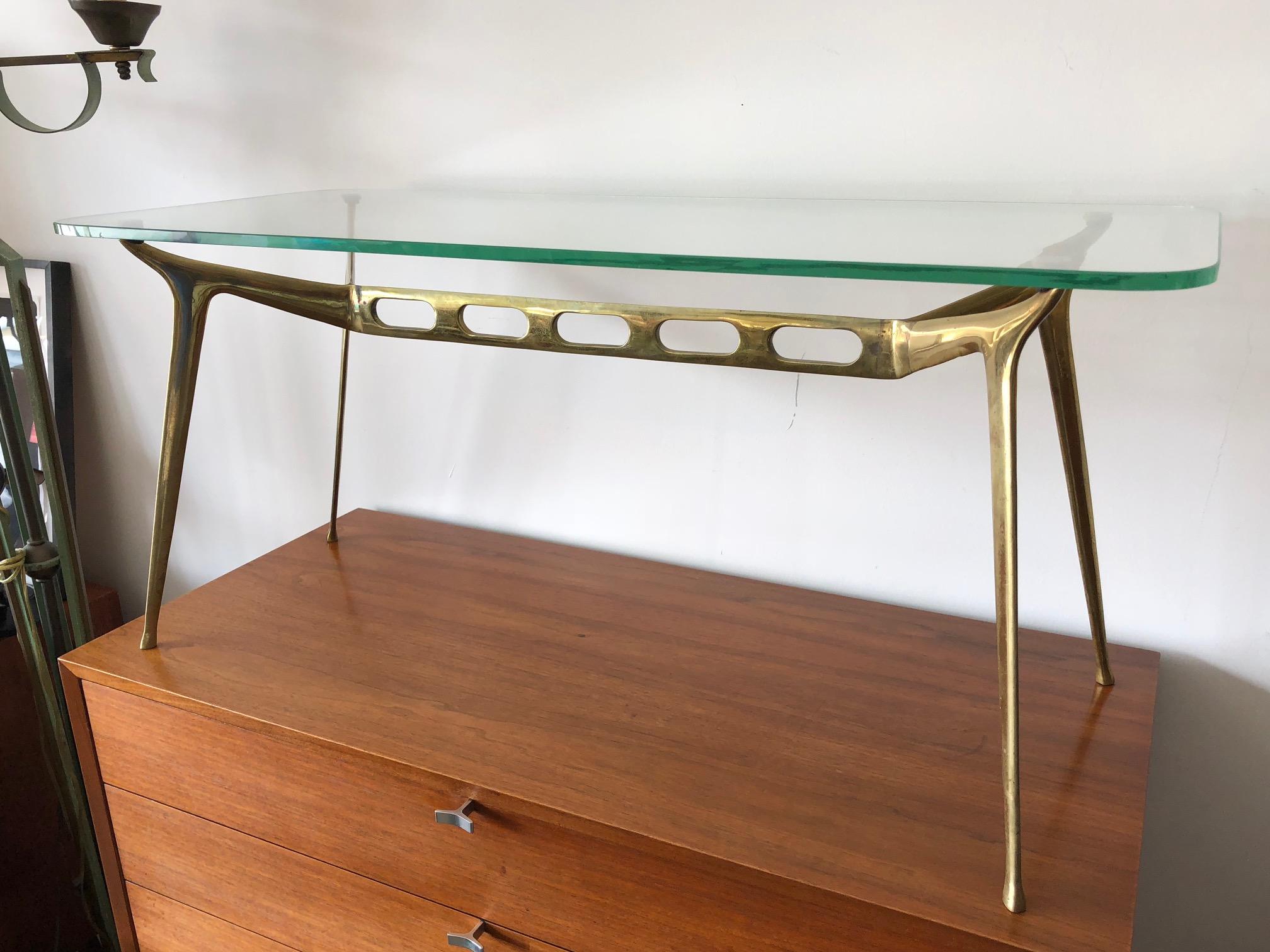 An elegant Cesare Lacca brass coffee table. Sculpted brass base with cutouts, original green tinted glass. Classic Italian 1950s style that fits in any decor and setting. This is a great example and rare to find.