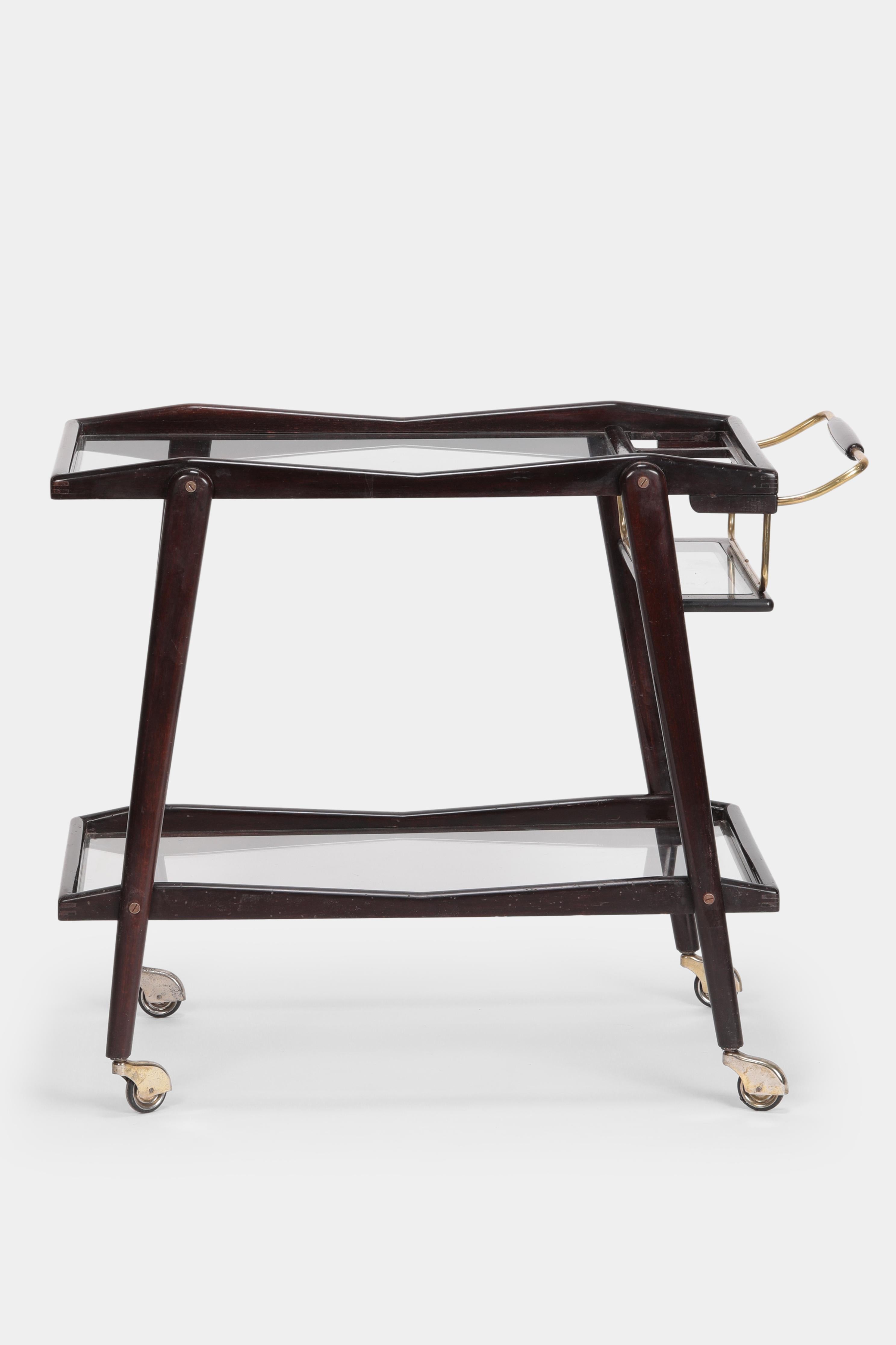 Elegant Italian serving trolley from the 1950s by Cesare Lacca with a lacquered mahogany frame and beautiful solid brass details. It has two glass shelves framed in wood. The trolley is in a beautifully restored vintage condition.