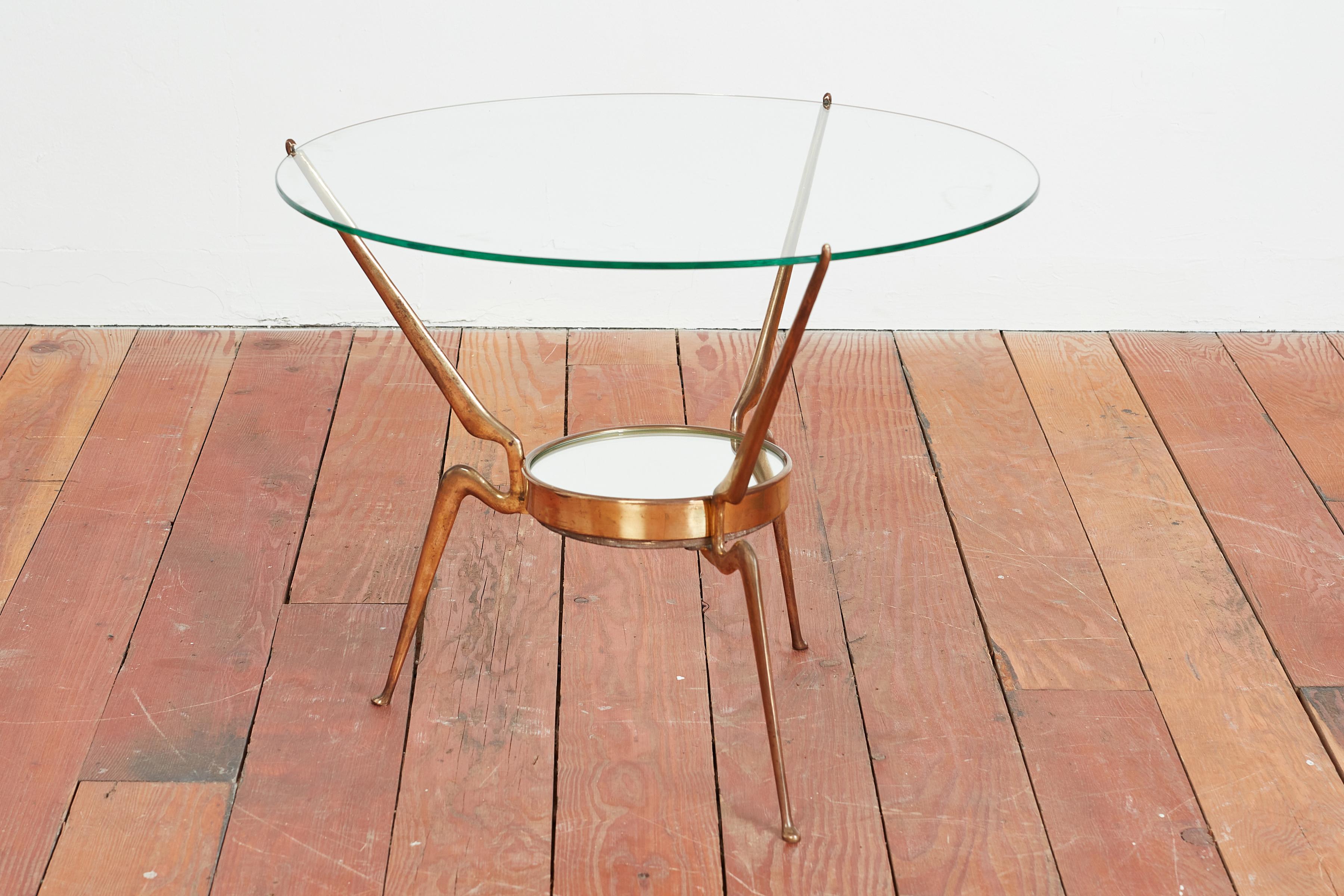 Incredible sculptural side table by Cesare Lacca 
Italy 1950's 
Solid brass tripod legs that are angled with a curve 
Delicately holds original glass top and round mirrored center piece within base. 
Wonderful design 