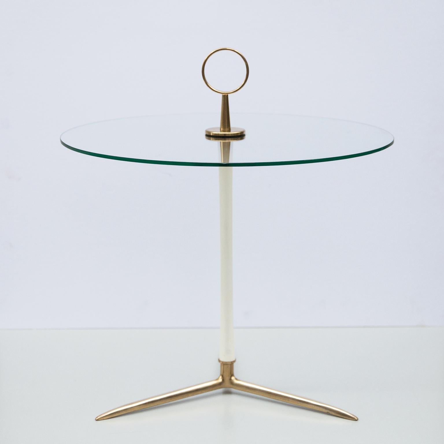 Sophisticated side and serving table designed by Cesare Lacca, Italy 1950. Manufactured in a brass tripod base with a white bar and a round brass handle to move it easily for serving drinks.

The original round glass top is in very good condition