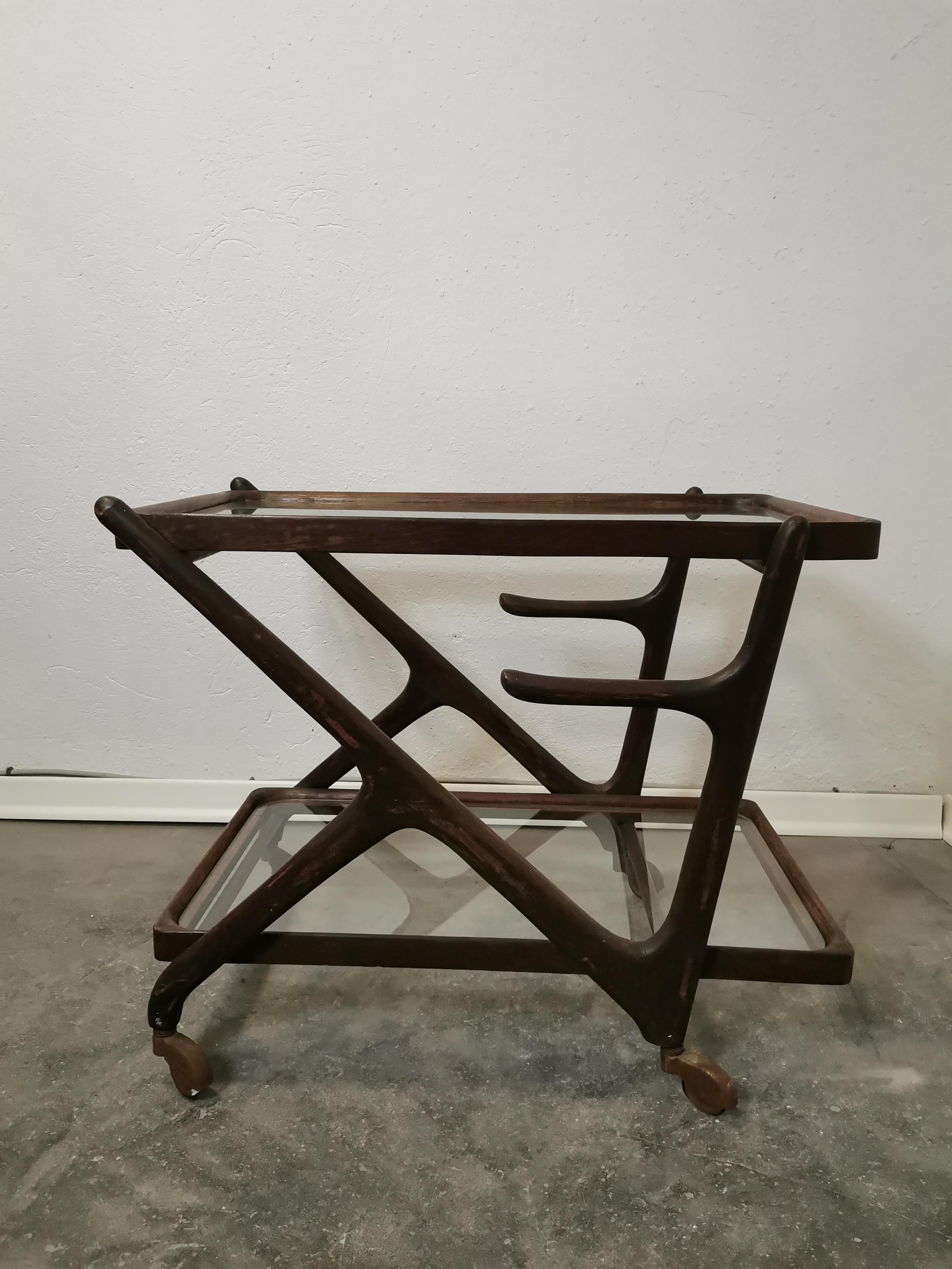 Cesare Lacca Trolley, Italy, 1950s. Trolley with a walnut wooden frame with two rectangular shelves with rounded corners, upper and down shelf loose and made of glass. H - 55cm, D - 86cm, W - 45cm.

Beautiful vintage patina