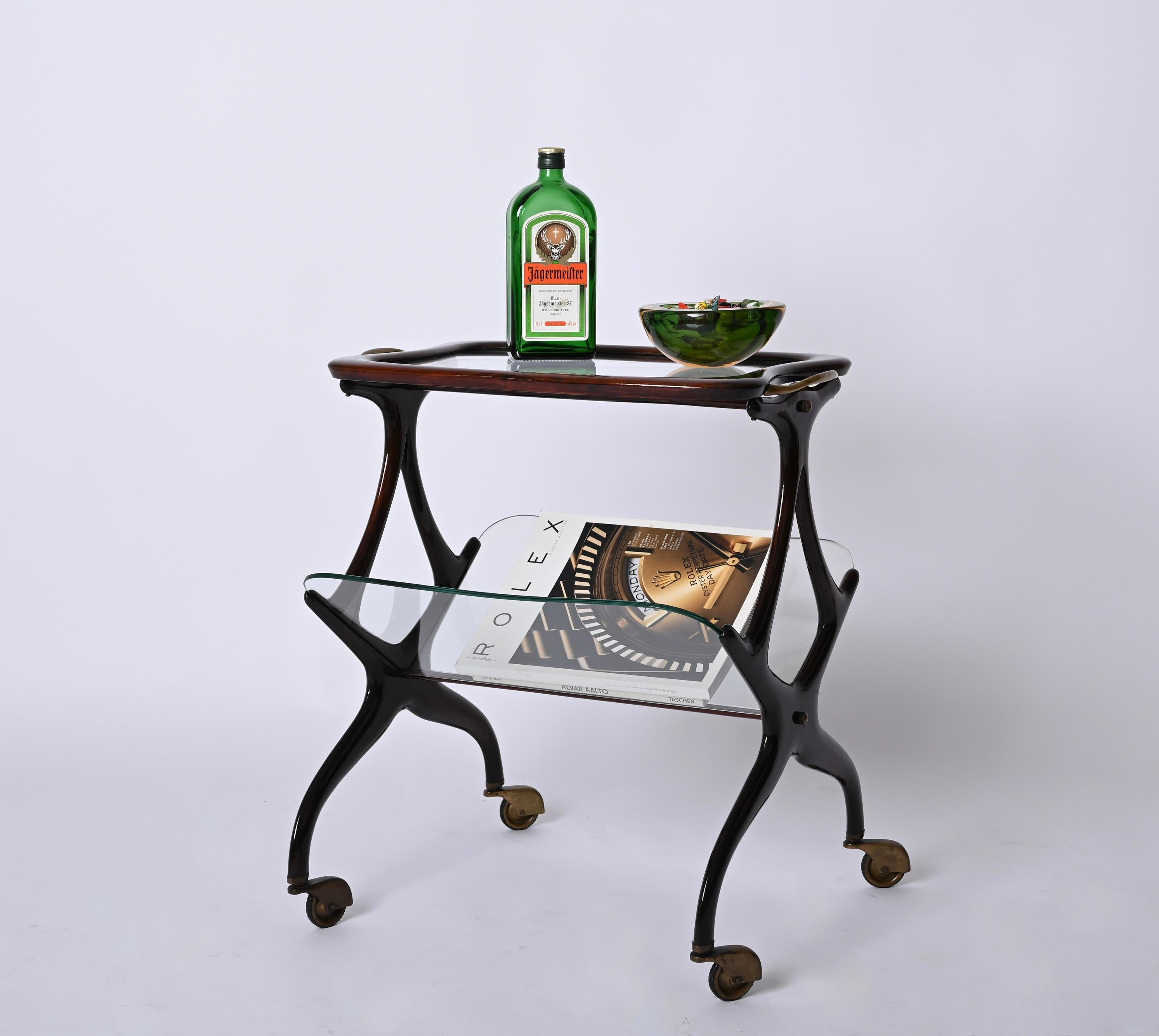 Marvellous Mid-Century bar cart with magazine rack and bar cart. This wonderful piece was designed by Cesare Lacca and produced by De Baggis in Italy during 1950s.

This elegant magazine rack features a V shaped bottom shelf with 2 crystal glasses
