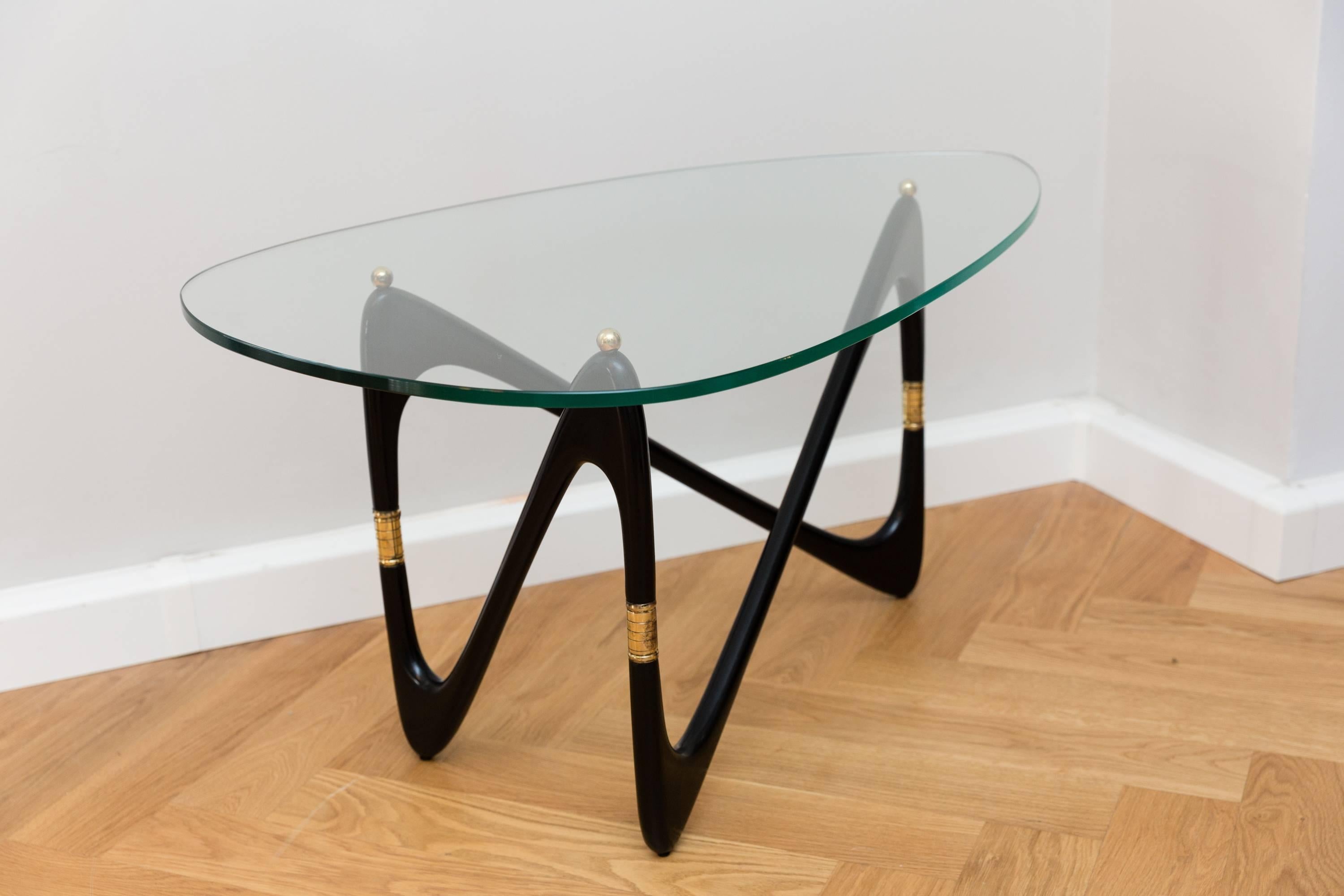 Rare Cesare Lacca coffee table, Italy circa 1950, elegant shaped shellack lacquered wood base, brass elements, polished brass balls, heavy 12mm glass top. Perfect condition, restored and new polished black shellack lacquer base.
No chips or