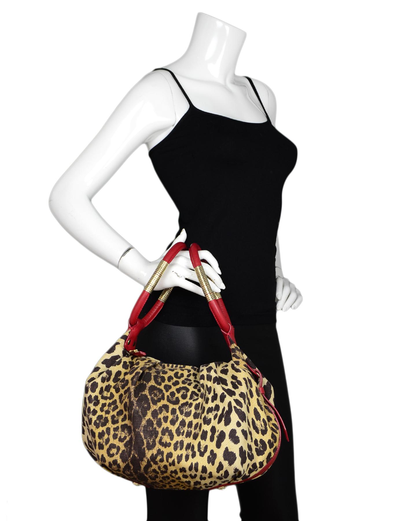 Cesare Paciotti Canvas Leopard Print Bag W/ Red Leather Trim 

Made In: Italy 
Color: Brown/tan, and red
Hardware: Goldtone
Materials: Canvas, leather, metal
Lining: Red satin textile
Closure/Opening: Zip top
Exterior Pockets: None
Interior Pockets: