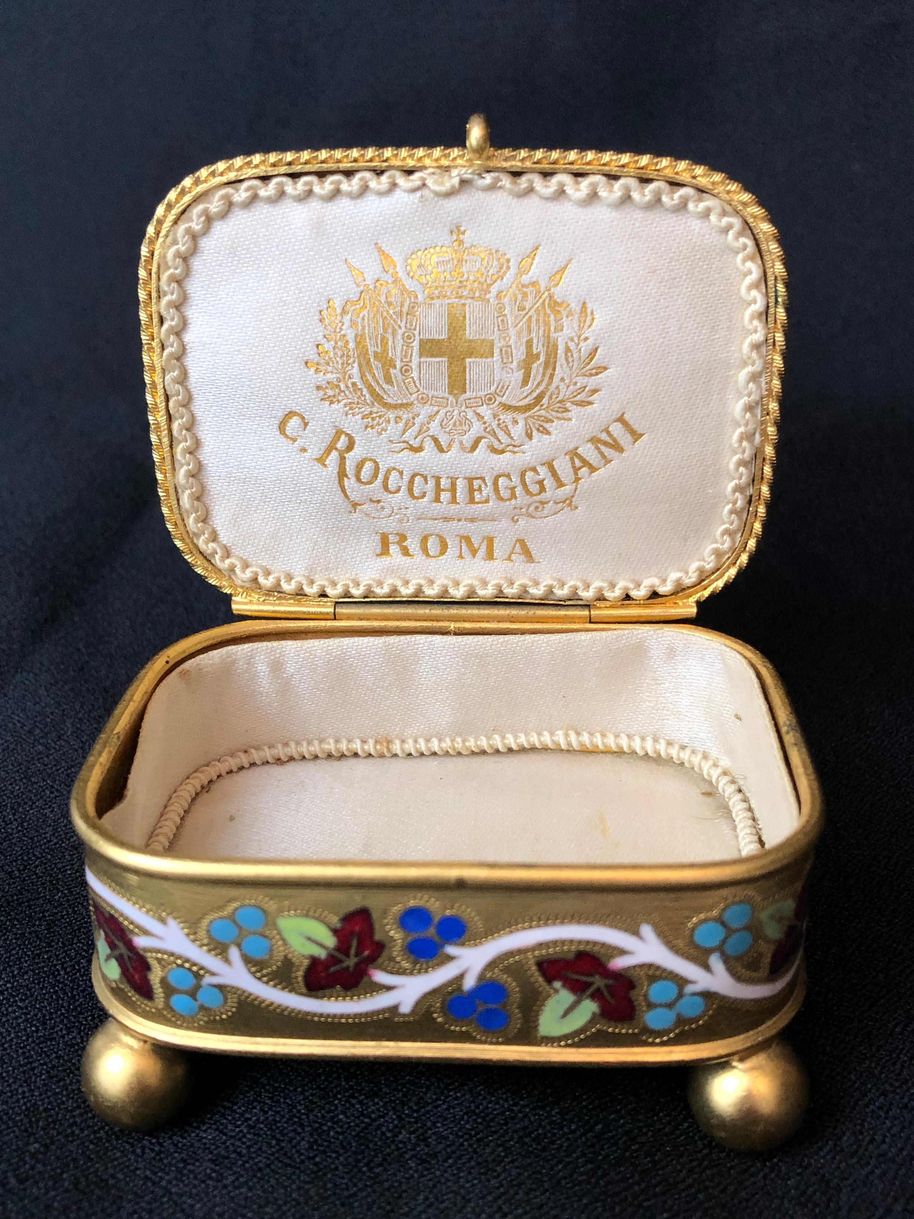 Italian micro mosaic gilt metal jewel box by Cesare Roccheddiani of Rome 

Chamfered onyx with inset medallions of scenes of Rome. Center image of the iconic birds drinking from a vessel 

With enameling on all sides. Bun feet 

Measures: