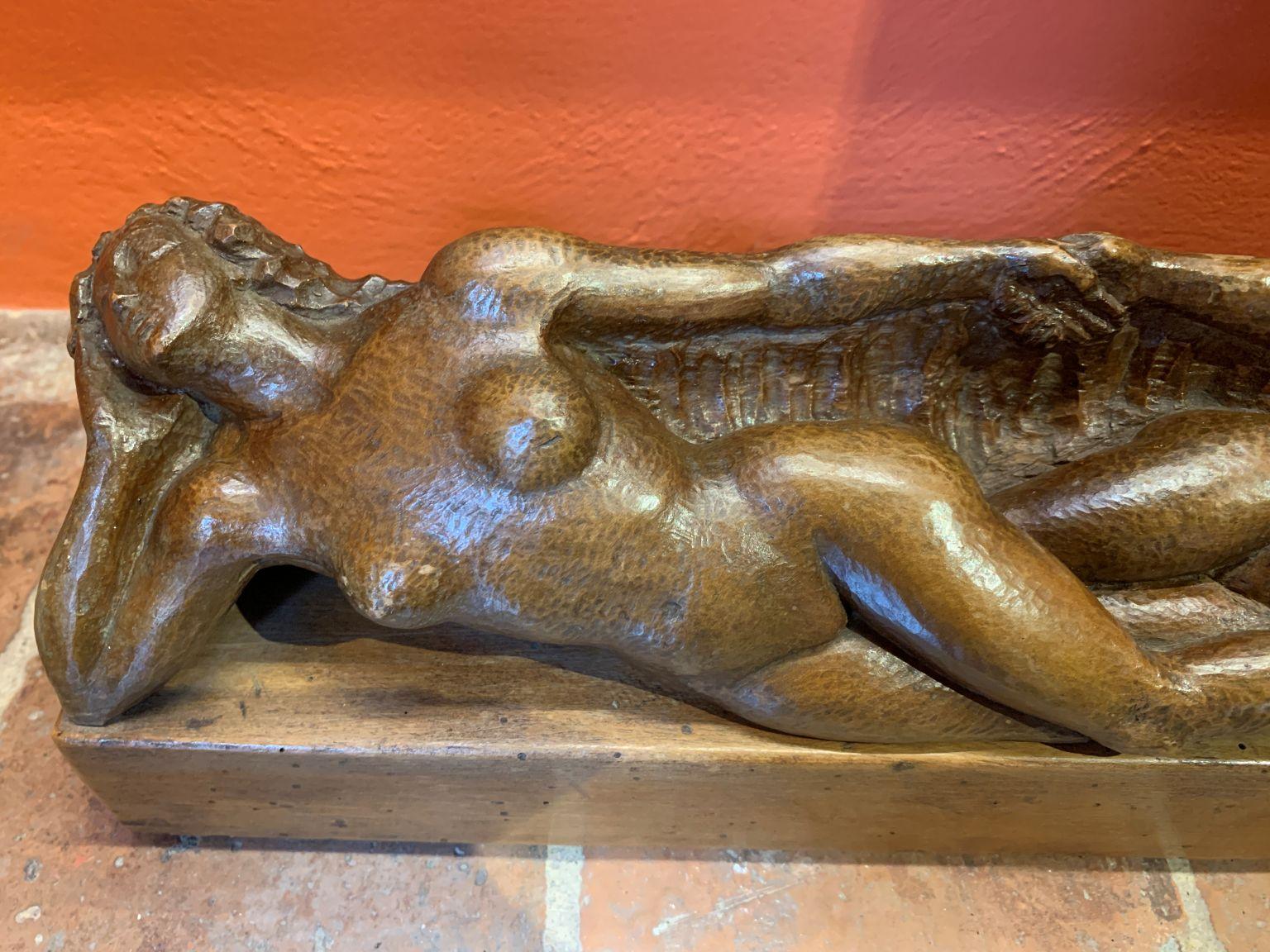 Pequeña escultura en madera (40 x 7 x 13 cm) con dos figuras femeninas desnudas y distantes que se agarran con la mano, sobre un fondo no reconocible pero que probablemente pretende enriquecer la naturaleza. La raffigurazione può avere un