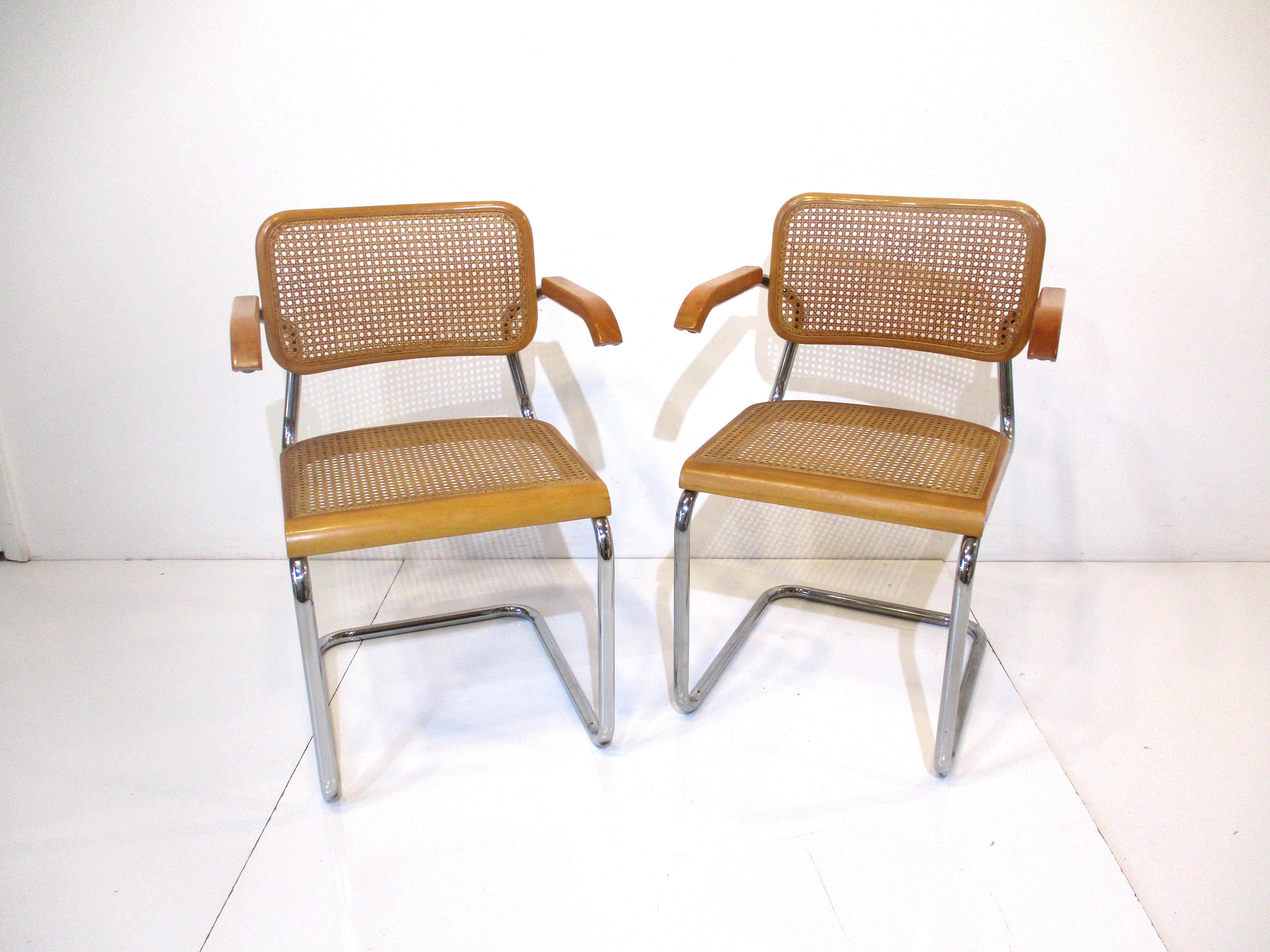 A pair of Cesca bent wood and caned arm chairs with sculptural chromed metal tube frames . A classic design by Marcel Breuer which has stood the test of time when produced 94 years ago and is still as fresh today as it was then . Super comfortable