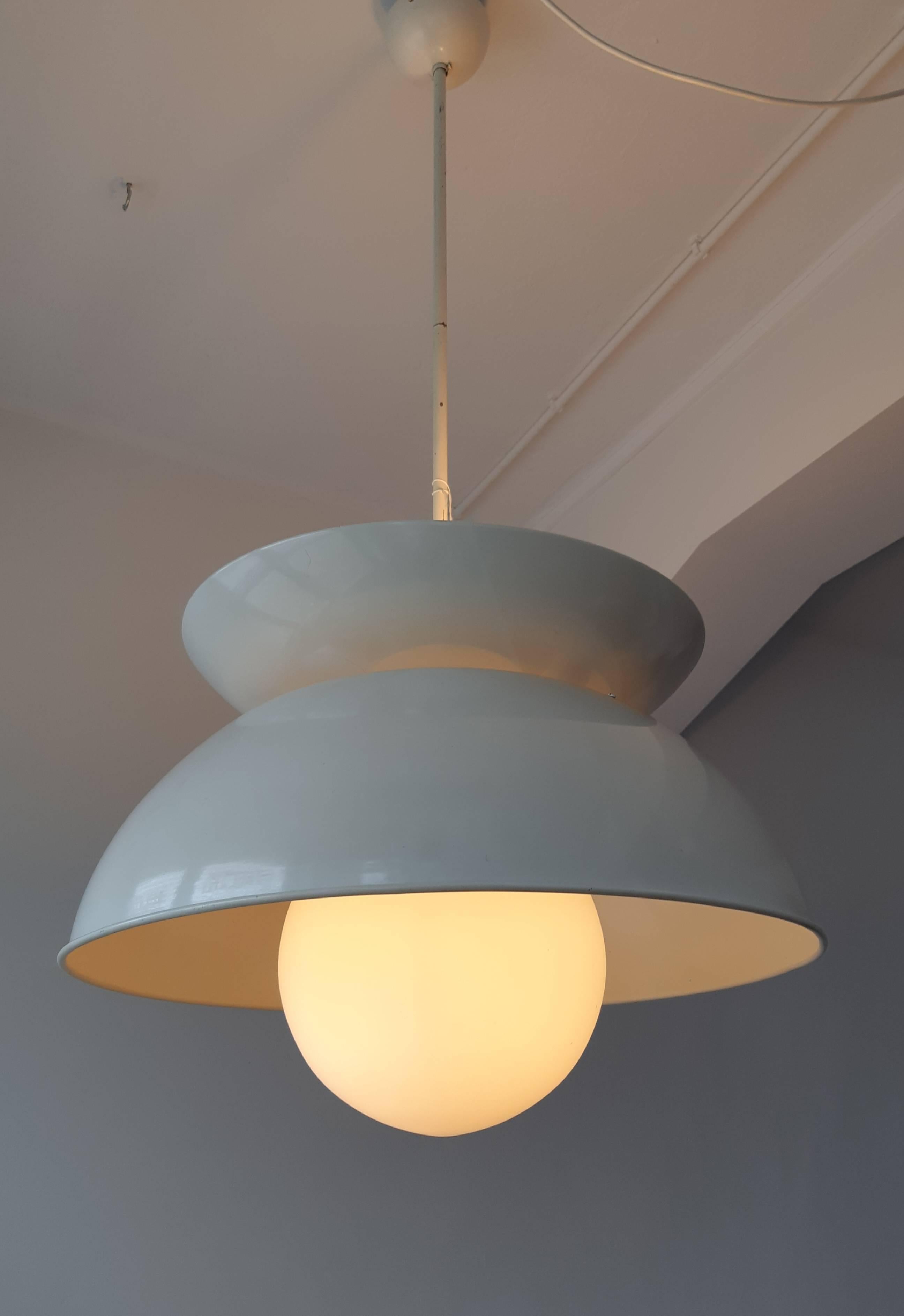 This midcentury Italian pendant lamp, model 'Cetra', is a design by Vico Magistretti for Artemide from the mid-1960s. The lamp, with a diameter of 56 cm, is made of white lacquered metal and has a matted opaline glass globe. It provides uplight and