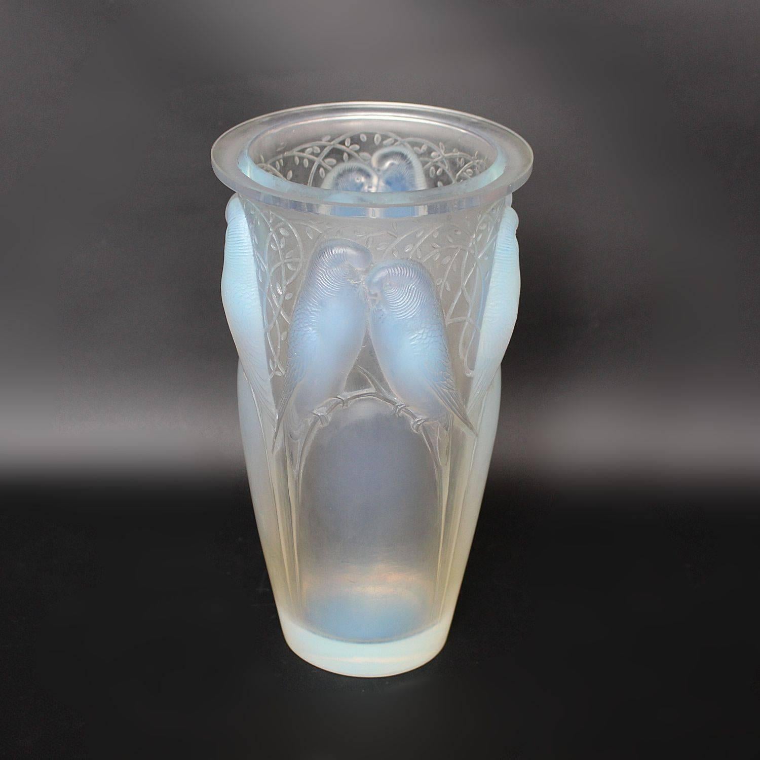 Ceylan, an Art Deco glass vase. A frosted and opalescent glass vase, relief decorated with pairs of lovebirds and vines.

Etched R Lalique France to underside.

Marcilhac, R Lalique Catalogue Raisonné de L’Œuvre de Verre p.418, model number