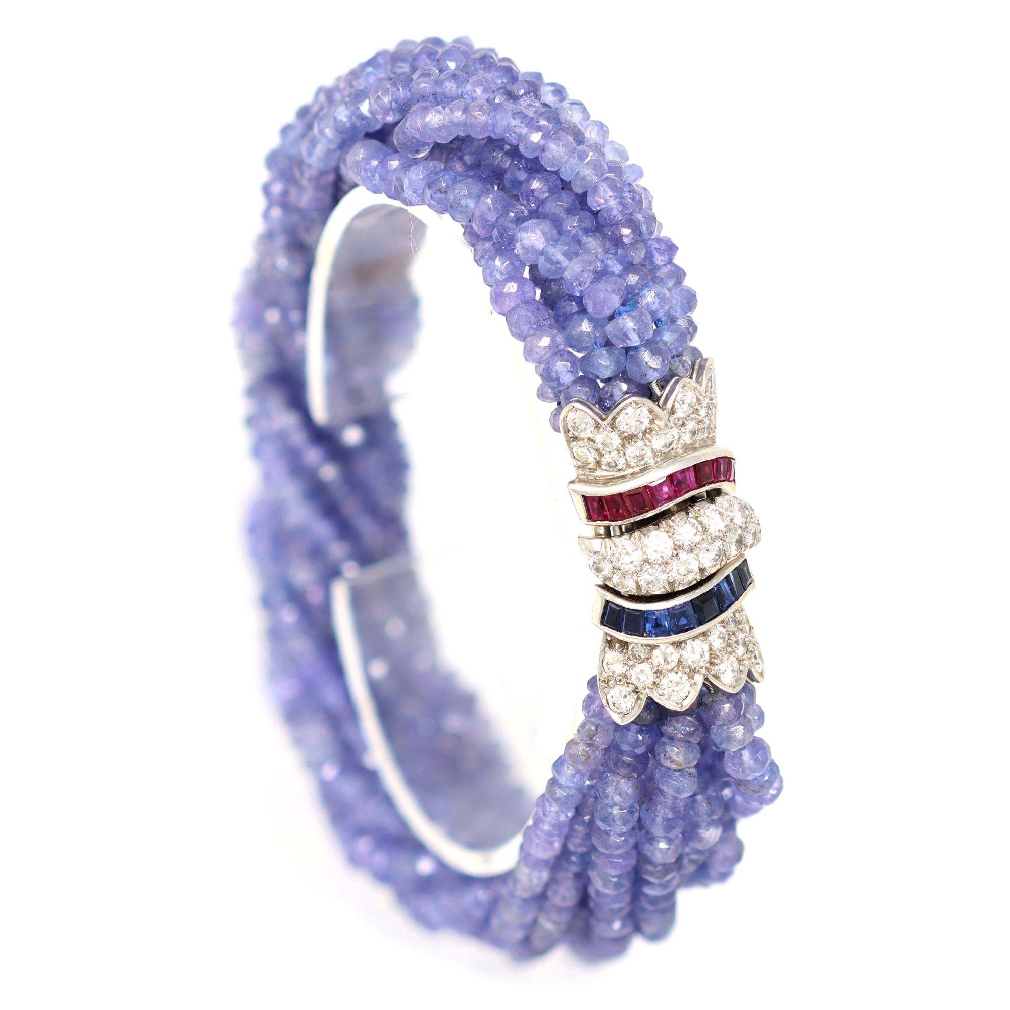 A faceted Ceylon blue sapphire bead multi-strand bracelet with diamonds sapphire and ruby clasp, set in 18K white gold, circa 1970. Made in the USA, this beaded bracelet is adorned with an exquisite clasp, presenting 0.80 carats of Ceylon blue