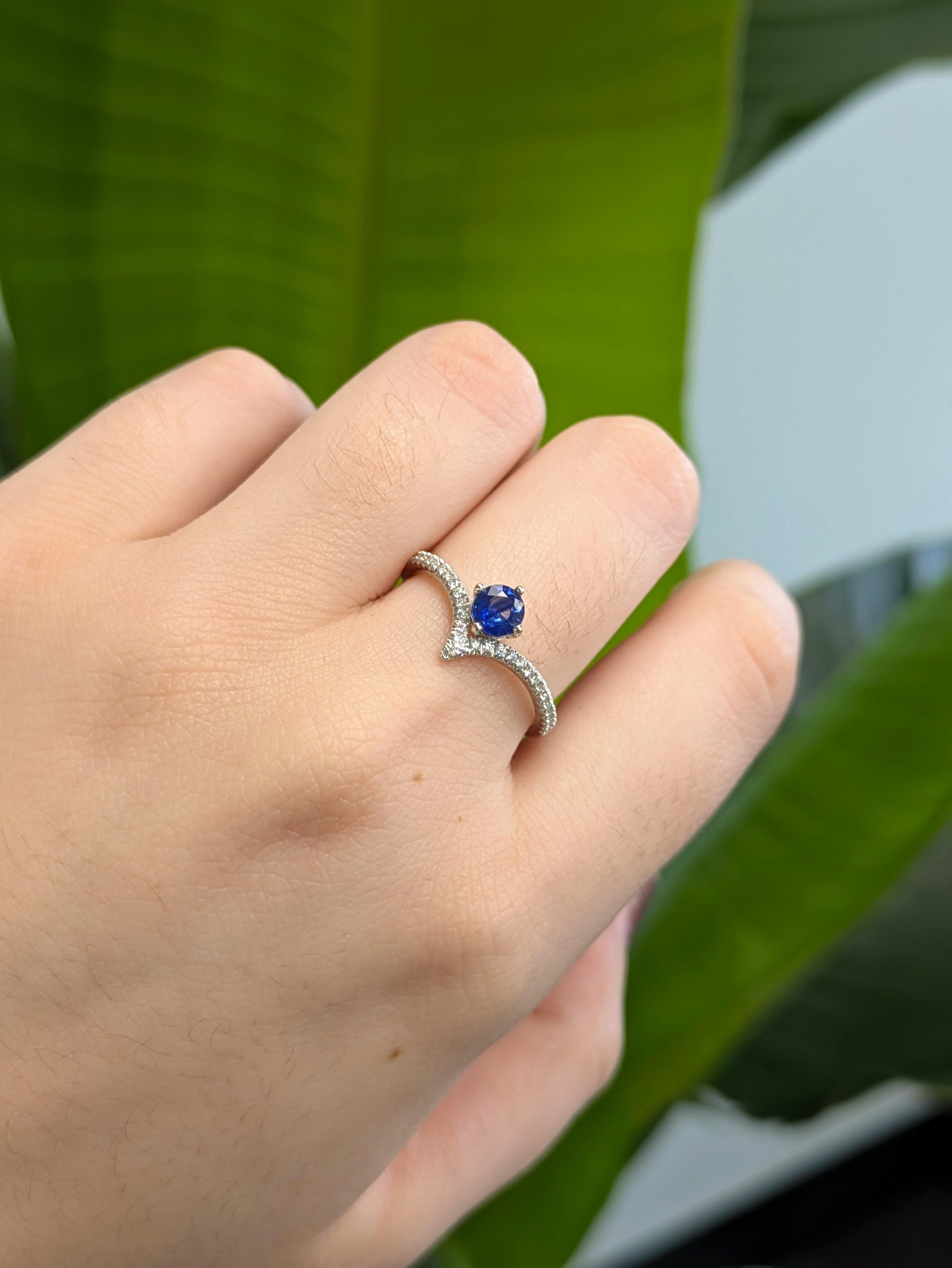 Un vibrante zaffiro blu è il protagonista di questo moderno anello a forma di V, dove le curve eleganti incontrano lo scintillio radioso. Il gambo con diamanti incastonati a pavé forma un grazioso avvallamento che attira l'occhio verso la gemma