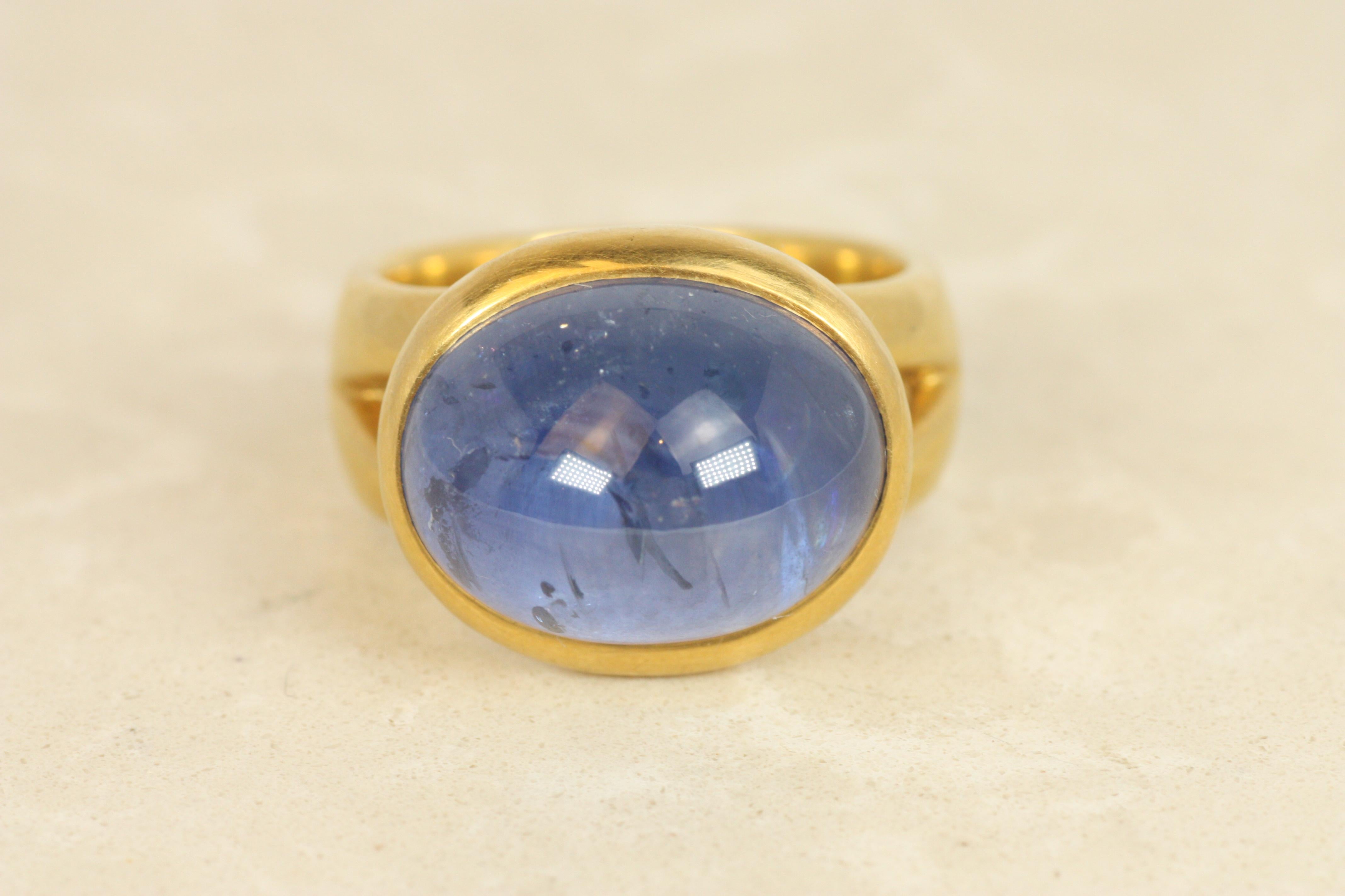 Vivid and regal, this 18.47ct Ceylon blue sapphire glows in a rich cornflower hue, cabochon cut to maximize its luminous depth. Set in a bold split-shank design crafted from 22K yellow gold, this ring embodies the spirit of ancient royalty and