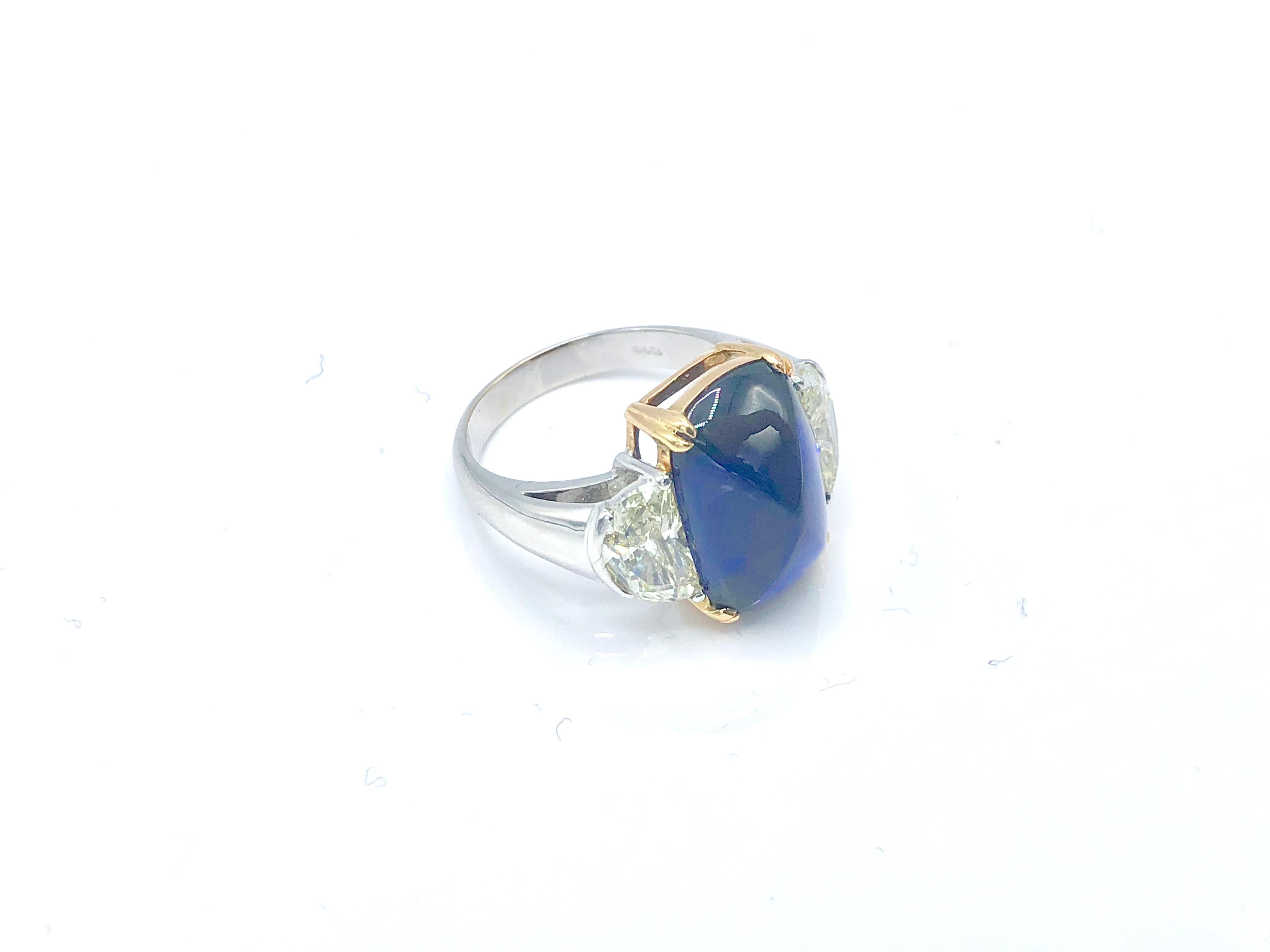 A spectacular ring centered with a Ceylon no heat flat cabochon sapphire in between two halfmoon diamonds.

Sapphire: 9.41 ct 
Diamonds: 2.03

Size: US 6 3/4