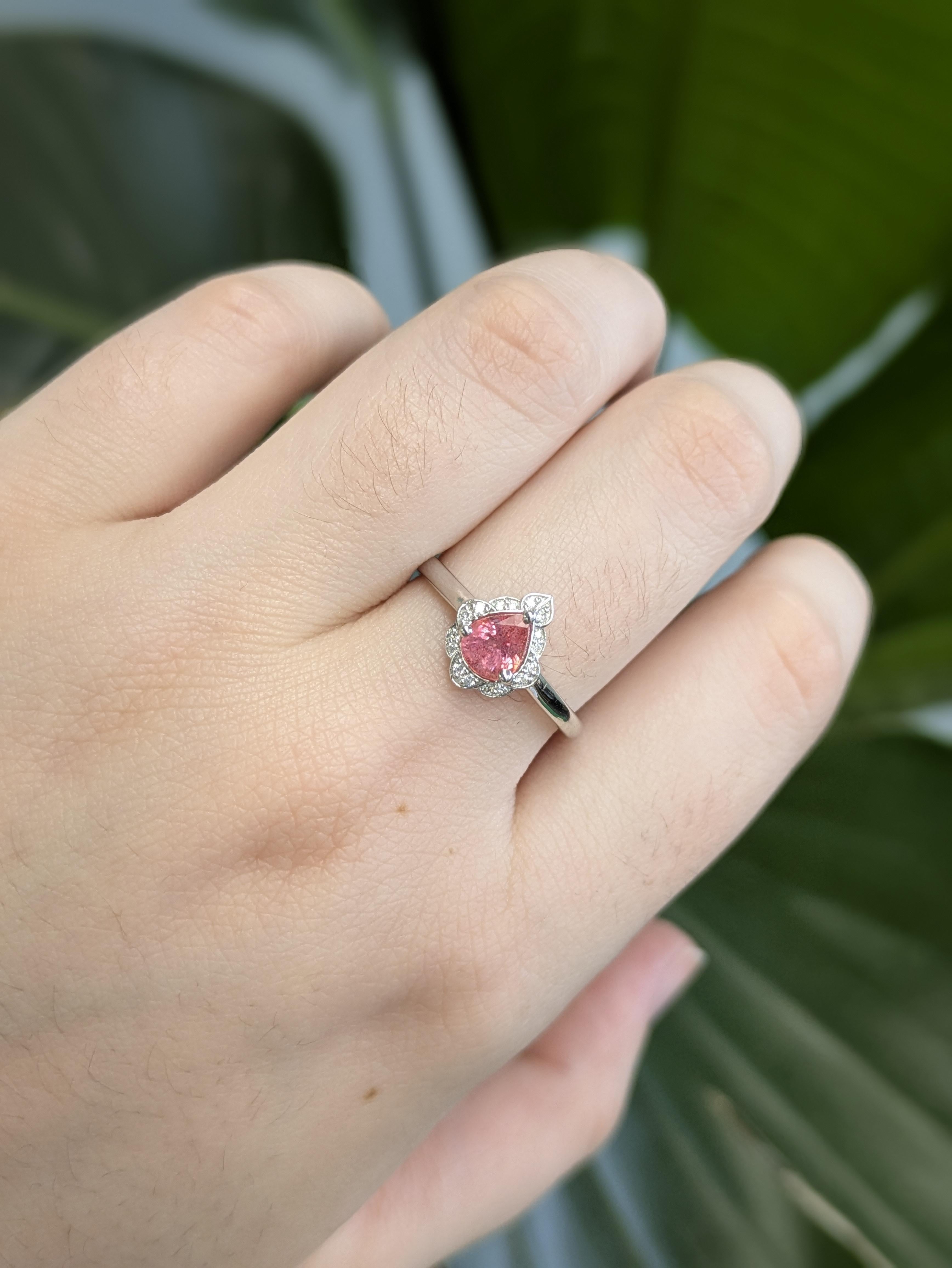 Abbraccia la rara bellezza di uno zaffiro Padparadscha da 0,68 carati, che brilla in un'accattivante miscela di sfumature rosa e arancioni. Incastonato in solido oro bianco 14k, questo squisito anello presenta diamanti naturali estratti dalla terra