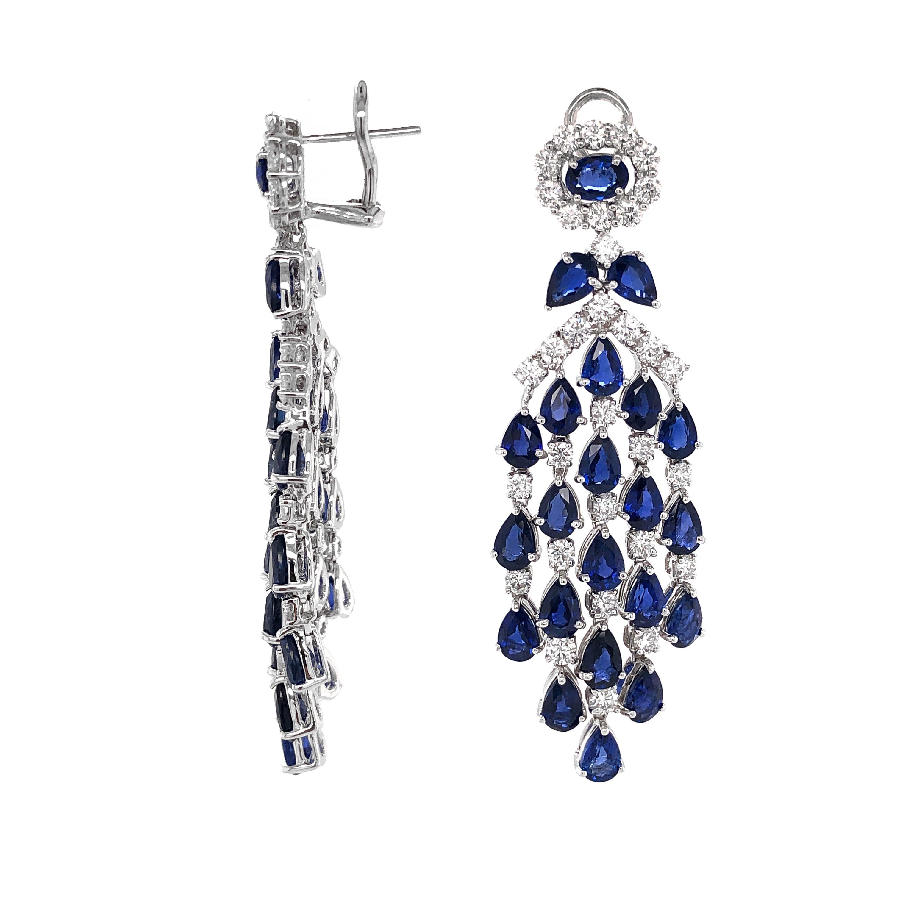 Dangling platinum earrings with pear and oval cut Ceylon sapphires 22.84 ct.
Accent of small round white diamonds 4.69 ct.
Diamonds are natural and in G-H Color Clarity VS.
Platinum 950 Metal. 
Omega / French clips.
Width: 2.1 cm
Height: 6.5