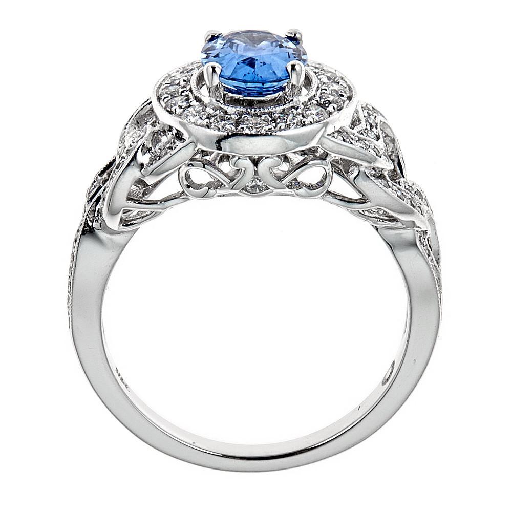 This handmade 14K white gold ring showcases a beautiful oval-cut Ceylon sapphire, and is studded with round brilliant diamonds.