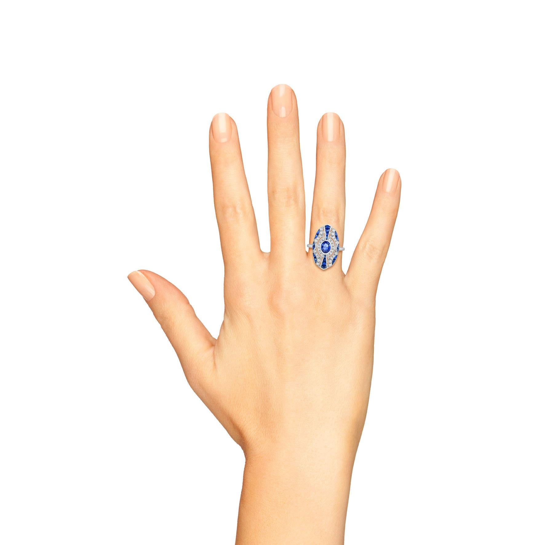Un saphir bleu de Ceylan, pesant 0,85 carats, brille au centre d'une bague de style Art déco à construction géométrique. La pierre précieuse est entourée de diamants ronds et de saphirs de taille française, accentués par un ajourage décoratif et de