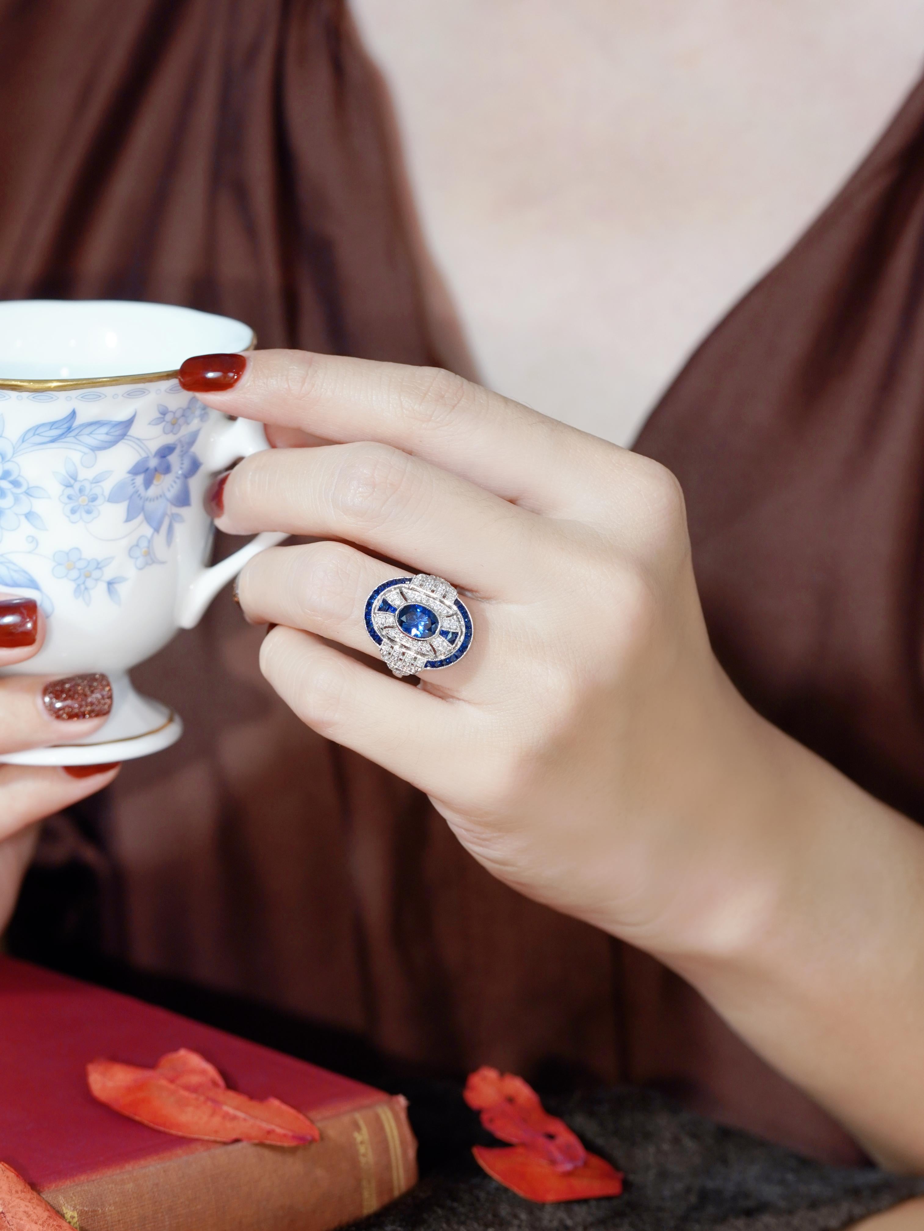 Uno zaffiro Ceylon ovale incastonato in un elegante castone, che mette in mostra la sua ricca tonalità blu. Il centro è affiancato sopra e sotto da zaffiri Ceylon taglio francese, che aggiungono simmetria e profondità. Diamanti scintillanti decorano