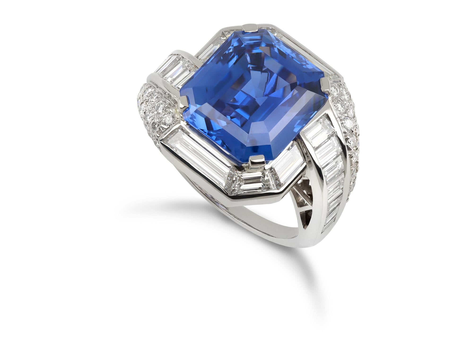 Ring mit Ceylonsaphiren und Diamanten. In der Mitte ein achteckiger, natürlicher Ceylon-Saphir im Smaragdschliff in einer offenen Krallenfassung mit einem Gewicht von 12,38 Karat, außerdem zwanzig spitz zulaufende Diamanten im Baguetteschliff in