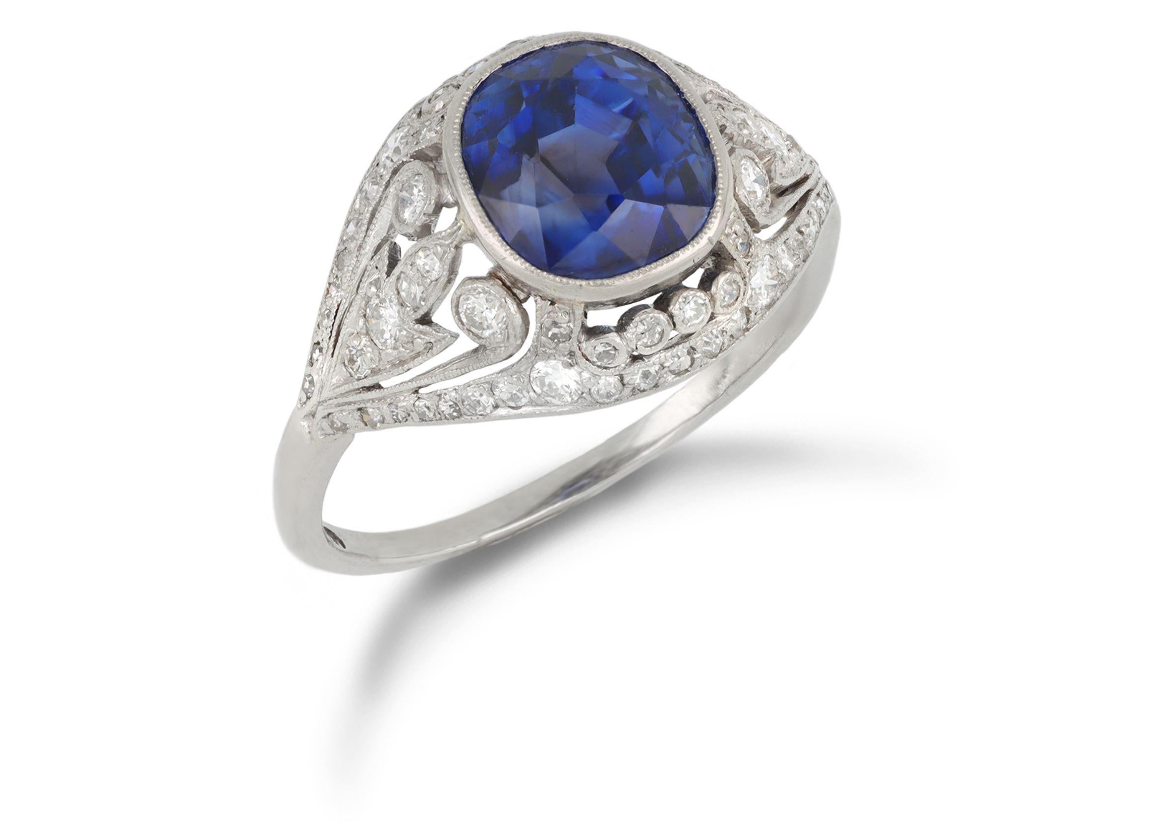 Anello con zaffiro di Ceylon e diamanti a grappolo. Al centro è incastonato uno zaffiro di Ceylon naturale non valorizzato a forma di cuscino con taglio misto in un'incastonatura rubover aperta sul retro con un peso di 4,40 carati, inoltre sono