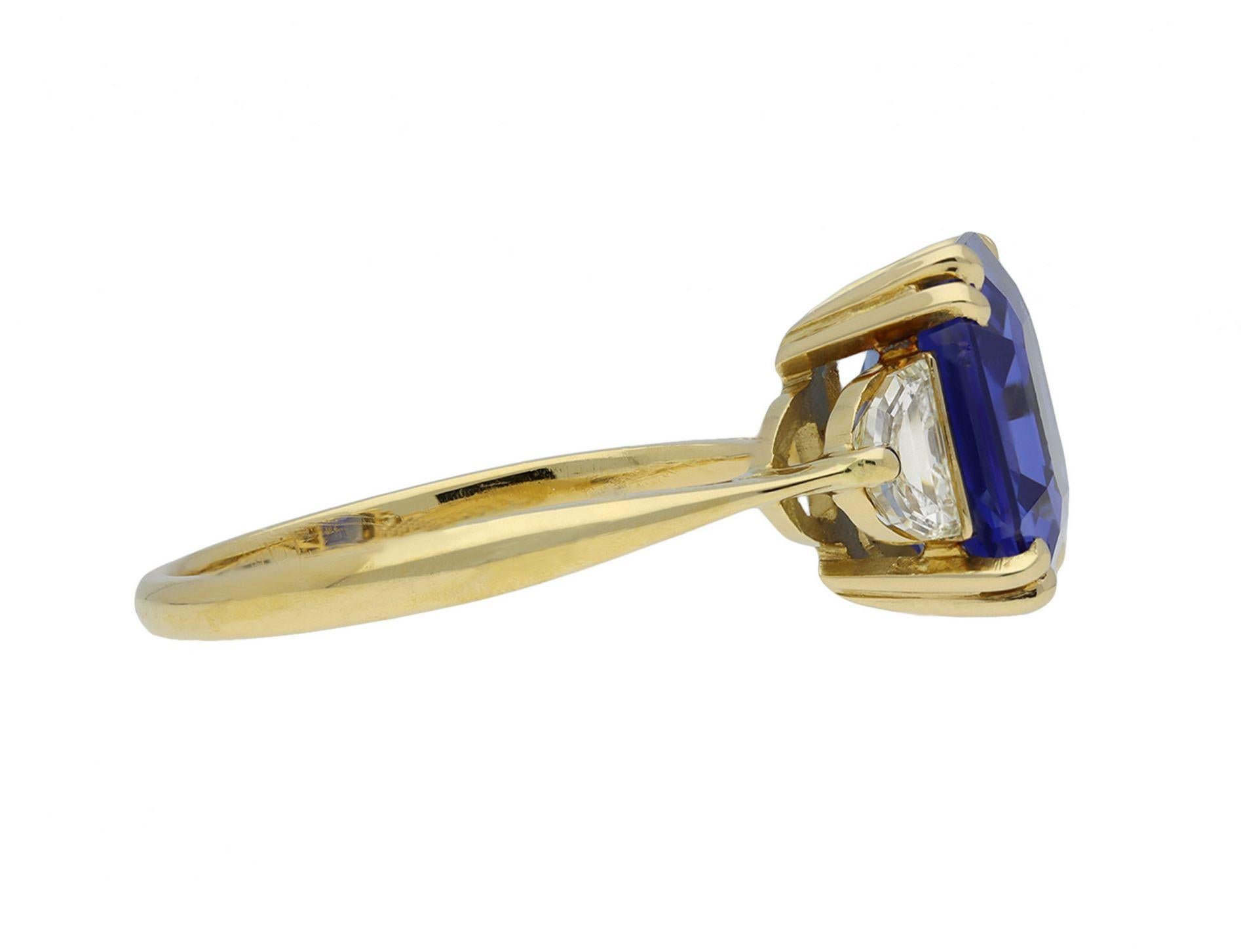 Ceylon sapphire and diamond ring. Set with an octagonal emerald-cut natural unenhanced Ceylon sapphire in an open back claw setting with an approximate weight of 4.15 carats, further set with two D-shape step cut diamonds in open back half rubover