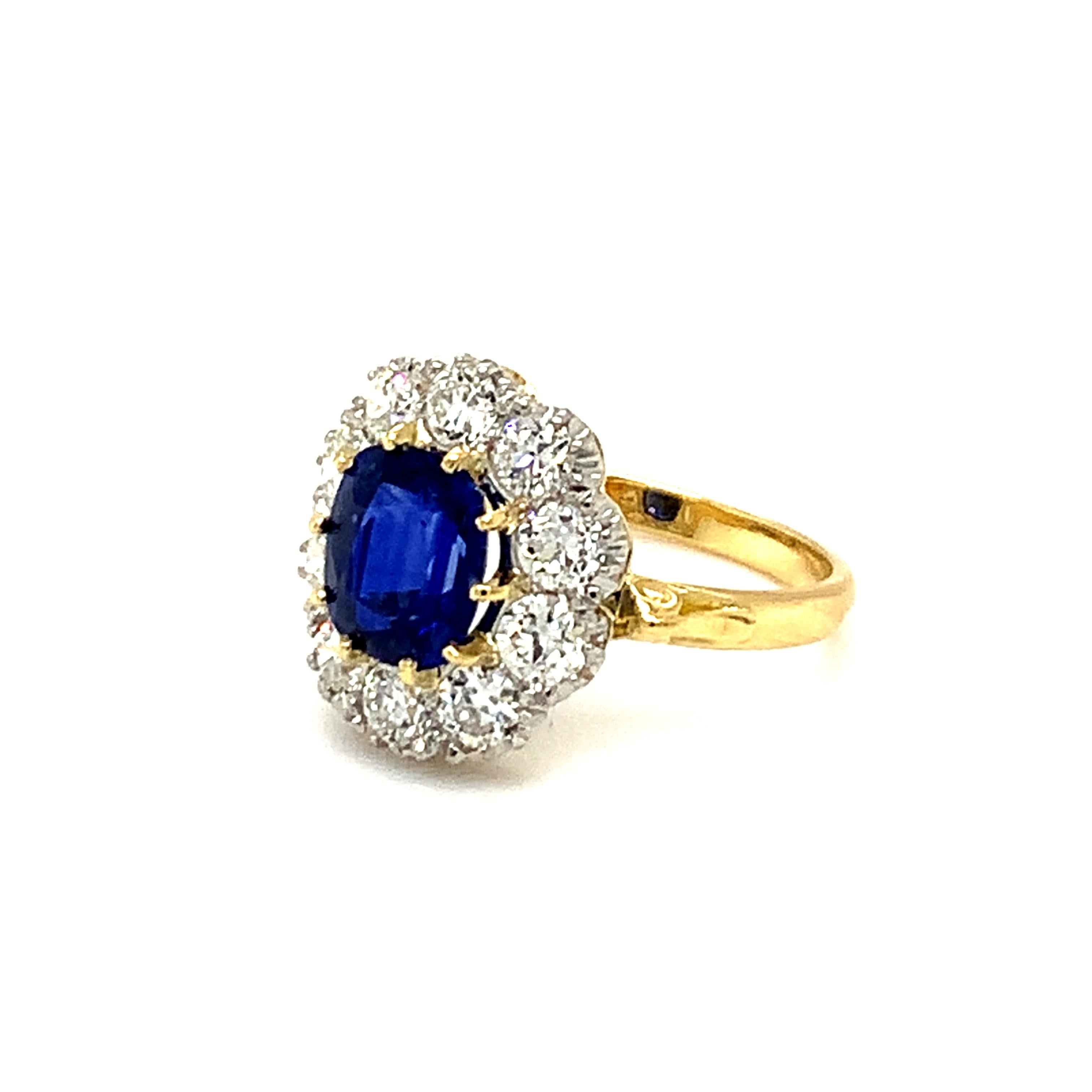 Stunning ultra fine cushion shaped Ceylon sapphire and old cut diamond cluster ring set in 18ct yellow gold and white gold. Modern ring made in Edwardian style, using old cut diamonds. Made by Joseph and Pearce in Sheffield, England.
Centre stone