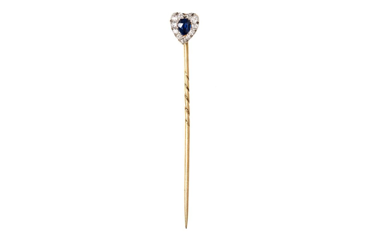 Victorian tie or lapel pin shaped as a heart with a central Ceylon sapphire and a surround of old cut brilliant diamonds. All mounted in silver and gold which is typical of the period.
Measures 6mm across.
Antique piece (over 100 years