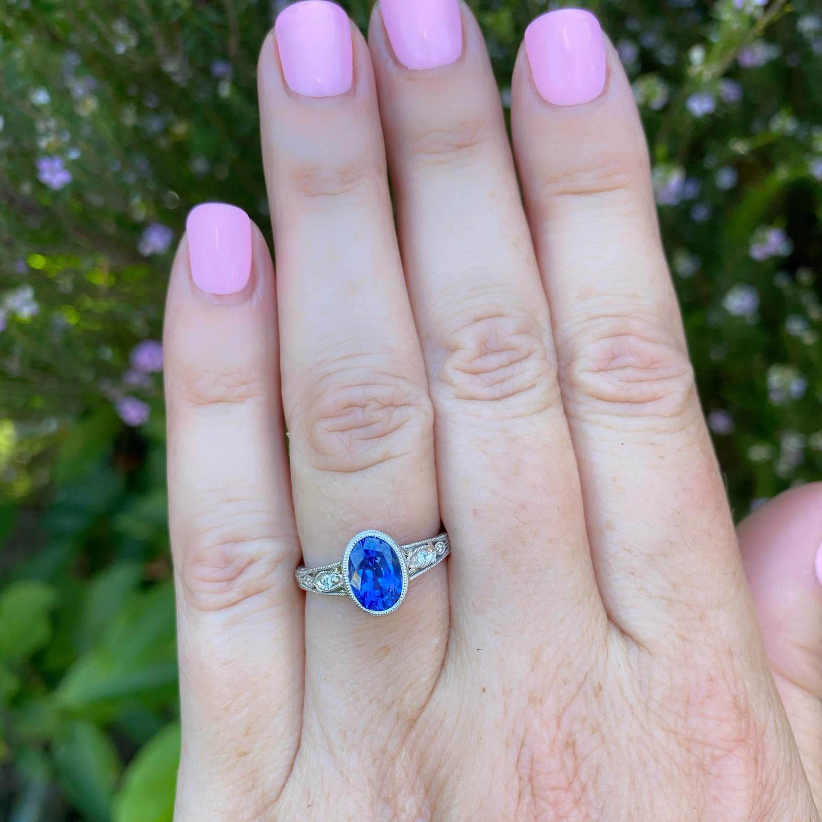 Edwardian style for contemporary taste! This platinum ring features a bezel-set 2.16-ct. oval-shaped Ceylon sapphire, vibrant and richly saturated color, accented with four bright round brilliant-cut diamond accents, weighing in total 0.04-ct.,