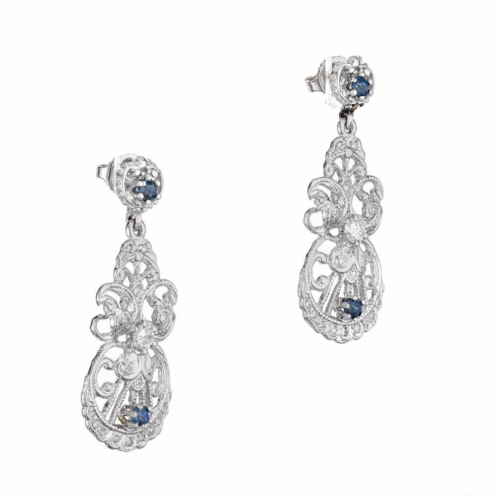 Sapphire and diamond dangle earrings. 32 round diamonds set in platinum with 4 round accent sapphires. Open work style. 

2 round diamonds approx. total weight .30cts
32 round diamonds approx. total weight .16cts
4 round sapphires approx. total