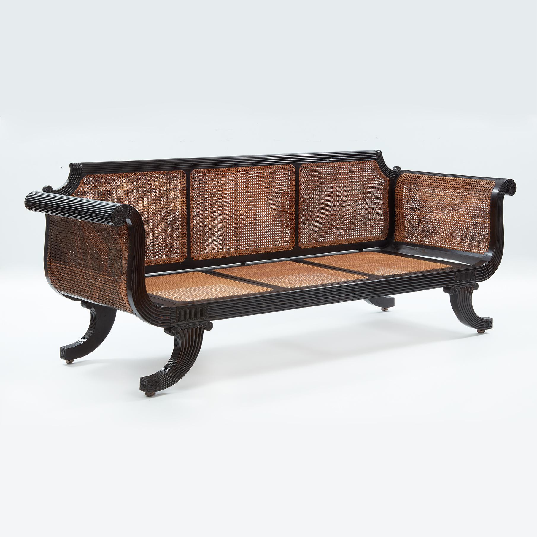 Ceylonese ebony framed sofa in regency style Circa 1830. Caned seats and back.