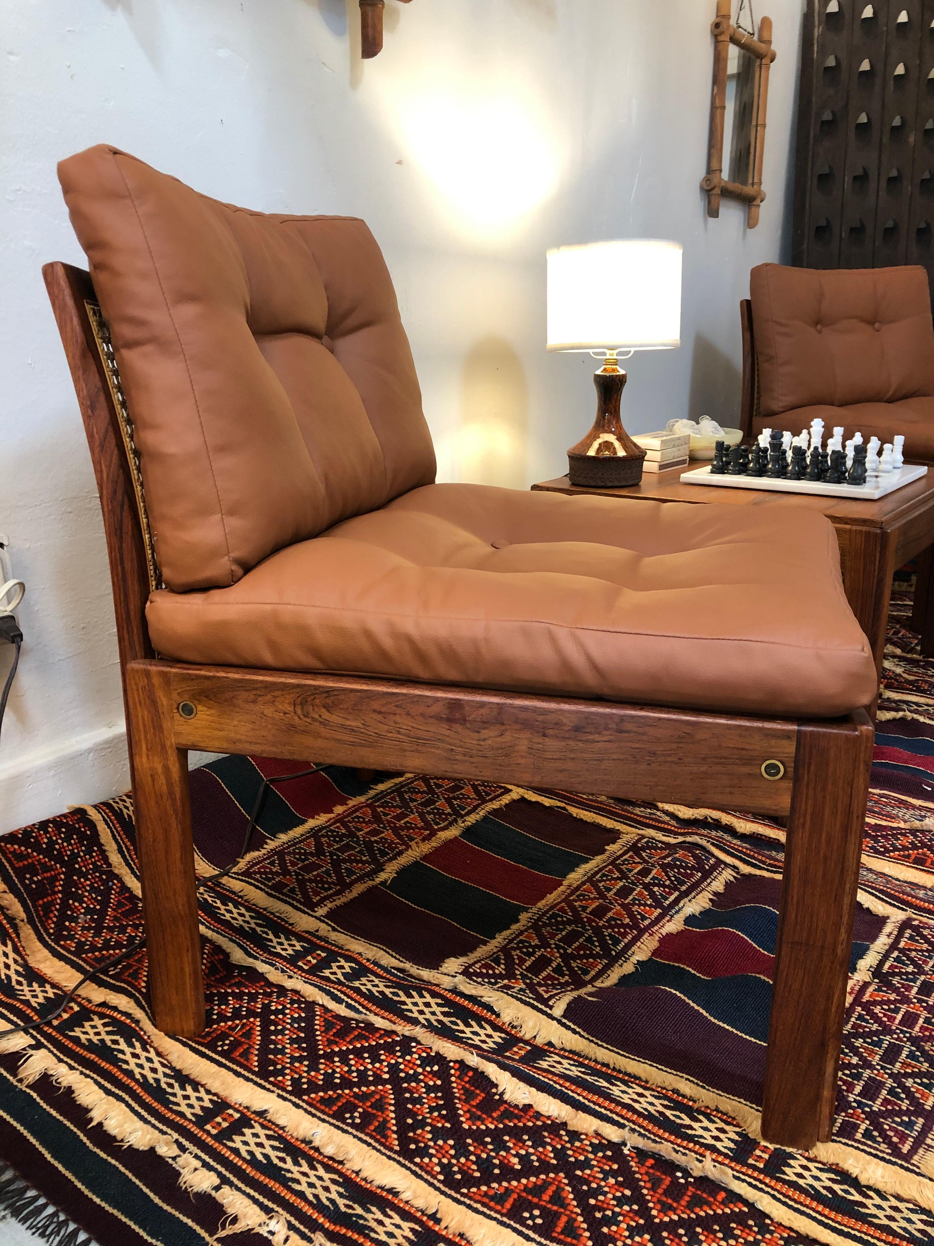 This original Danish set, designed by Johannes Andersen for CFC Silkeborg, is in mint condition from the 1960s. Chairs are made in teak wood with rattan seat backs. Fitted with soft tufted leather seat cushions. The table with this set is also made