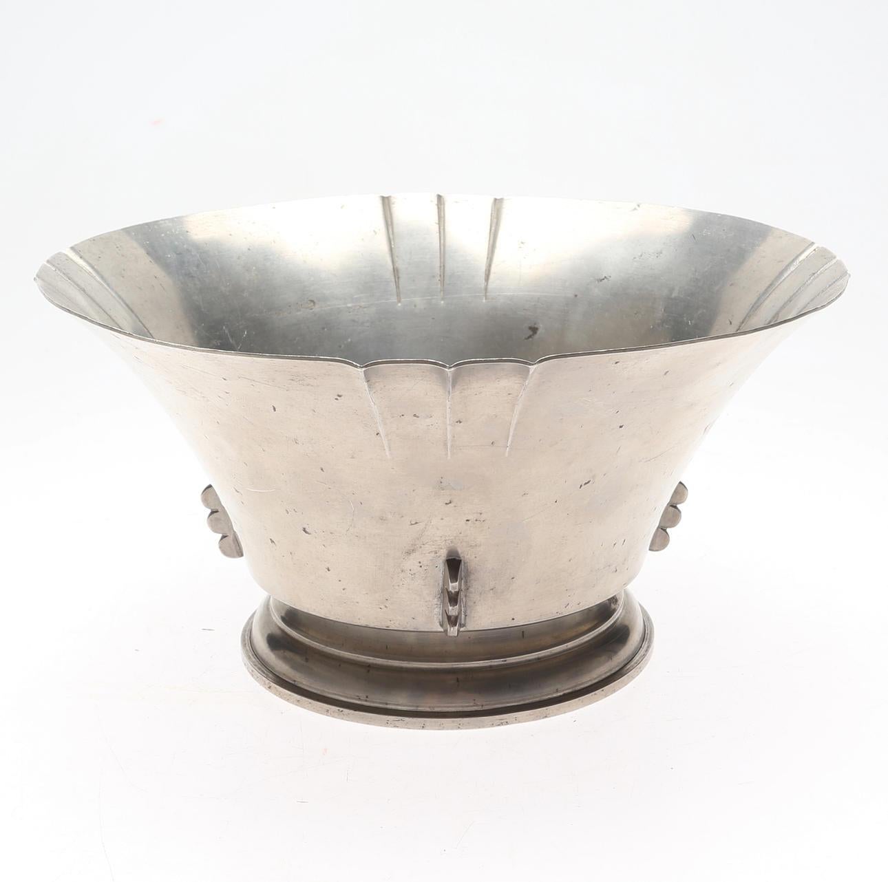 Elegant Art Deco pewter bowl designed and crafted by the renowned Swedish firm CG Hallberg in 1931. This beautifully flared piece features a gently scalloped rim with subtle vertical fluting and decorative side elements, resting on a stepped