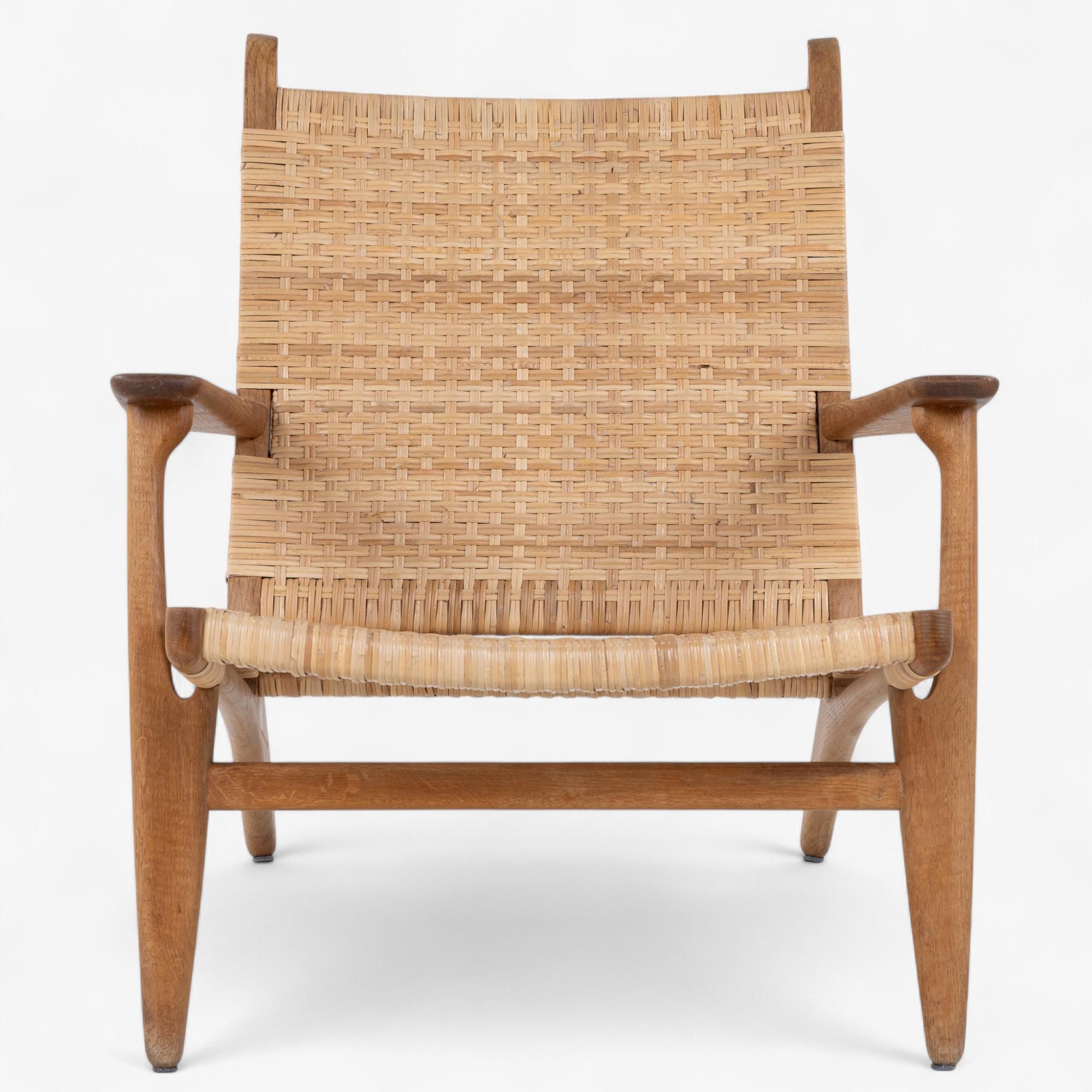CH 27 - Sillón de roble patinado con respaldo y asiento de mimbre. Diseñada en los años 50.