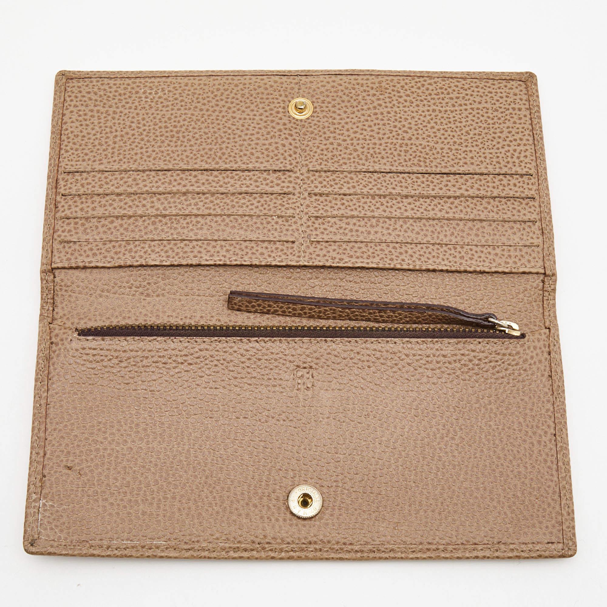 This CH Carolina Herrera bifold wallet has been expertly crafted from beige leather into a flap style. It opens to reveal a neatly organized interior that can hold your cards  currency  and coins. It is sure to come in handy.