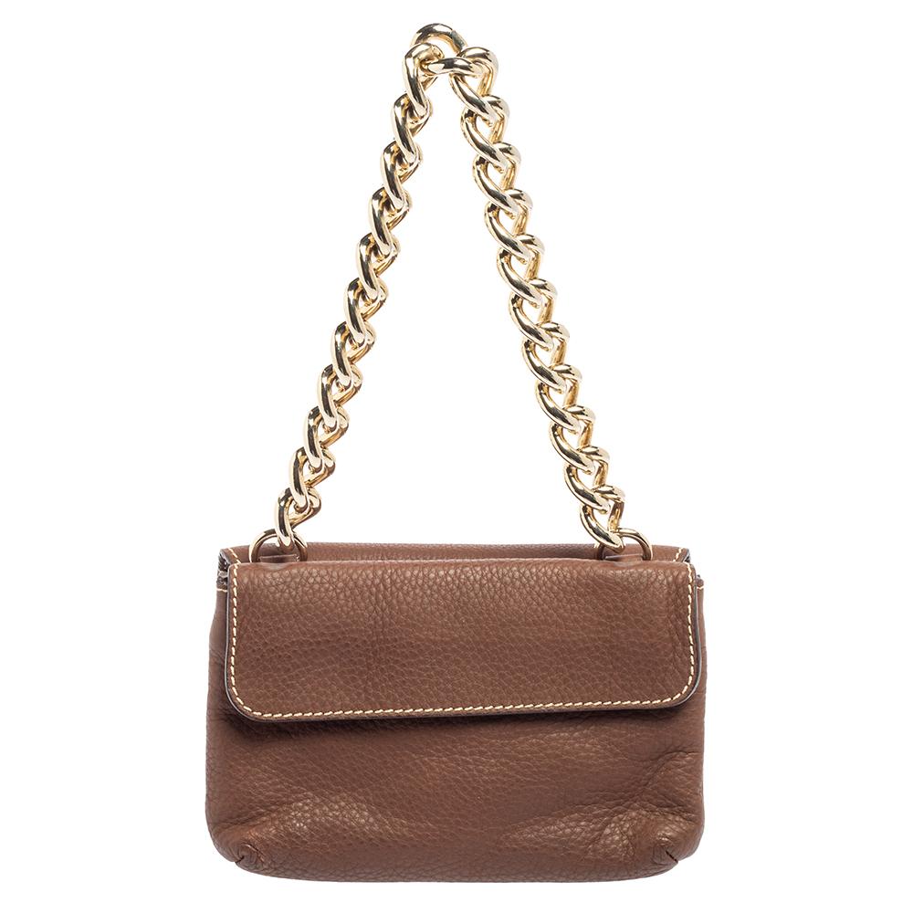 Coming from the House of CH Carolina Herrera, this bag is an absolutely chic accessory you need to own today! It is made from brown leather, with a gold-toned CH logo decorating the flap. It has a fabric-lined interior and comes with a chain strap.