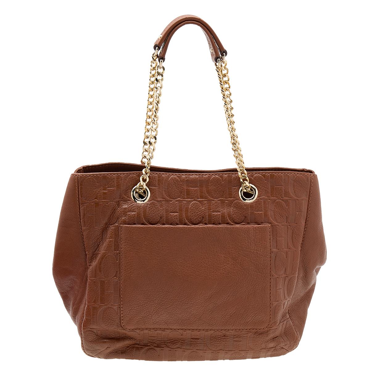 This Audrey tote from CH Carolina Herrera is a beloved creation. It is made using brown Monogram-embossed leather on the exterior. It is decorated with a large bow accent and distinct gold-toned hardware. This Audrey tote is held by sturdy chain