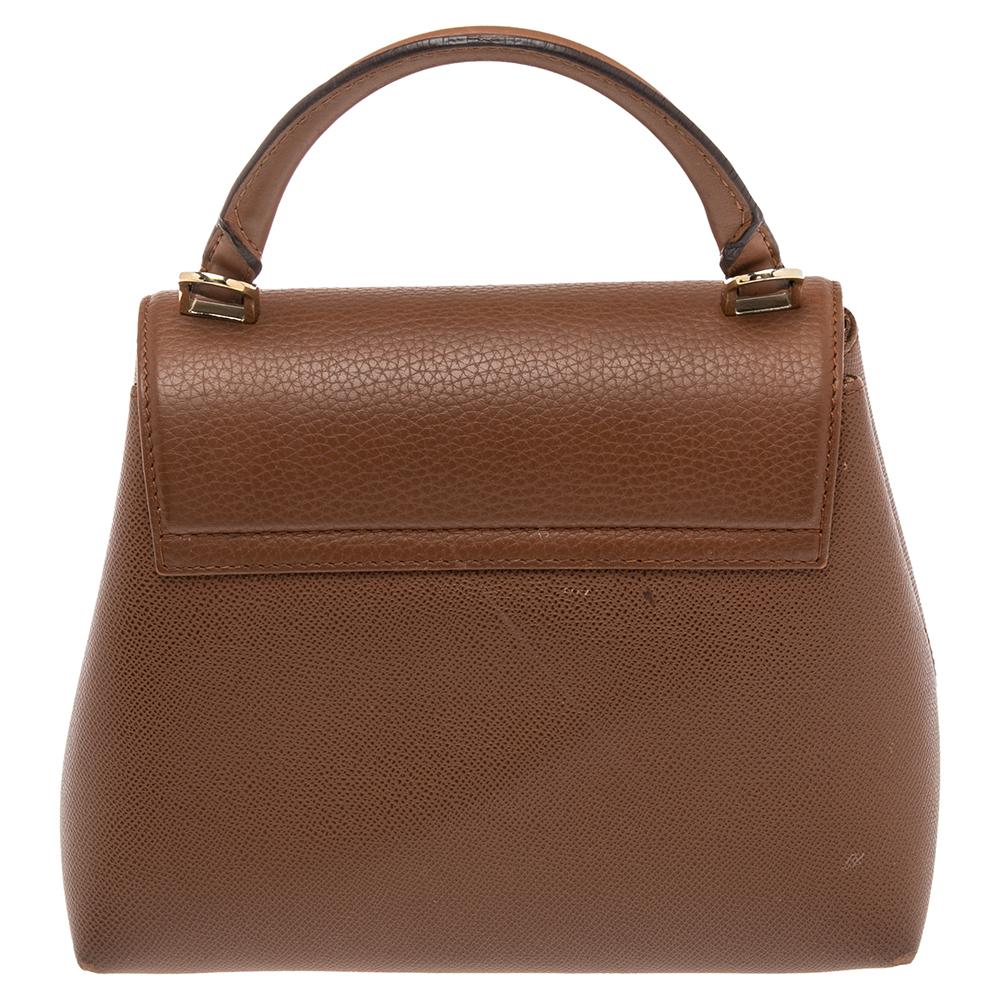 This bag from CH Carolina Herrera is classy, chic, and effortlessly stylish! It has been crafted from leather and designed with a front flap that carries a gold-tone lock. It is held by a top handle and opens to an interior that can smoothly