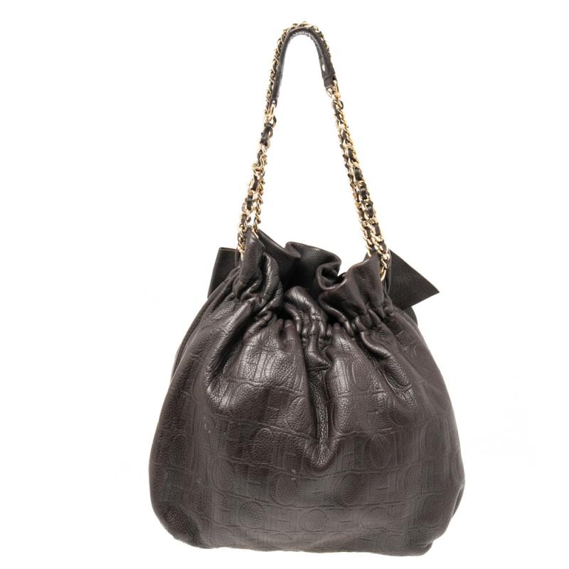Crafted with monogram-embossed leather, this chic CH Carolina Herrera bag is detailed with a bow at the front. This bucket bag is complete with a spacious fabric-lined interior and a leather-chain woven handle link. It will be a smart addition to